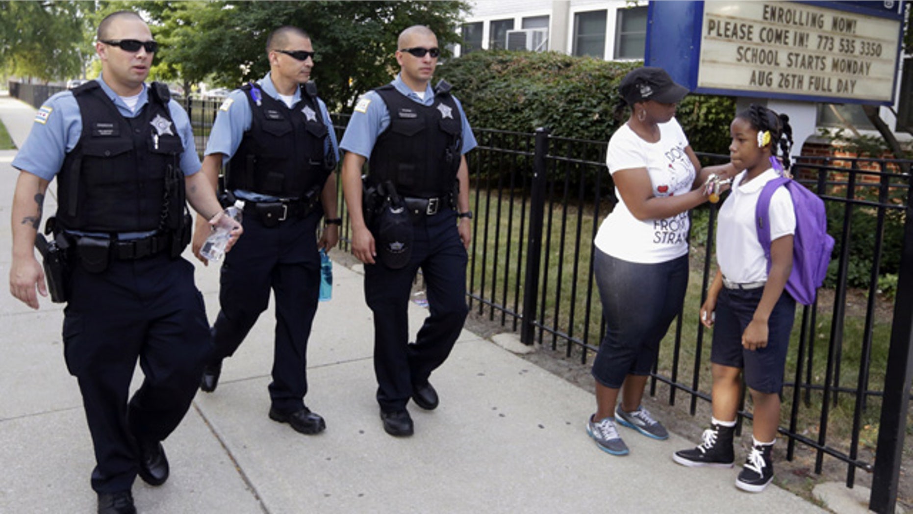 FILE - In this Aug. 26. 2013, file photo, Chicago Police patrol the neighborhood at Gresham Elementary School on the first day of classes in Chicago. (AP Photos/M. Spencer Green, File)