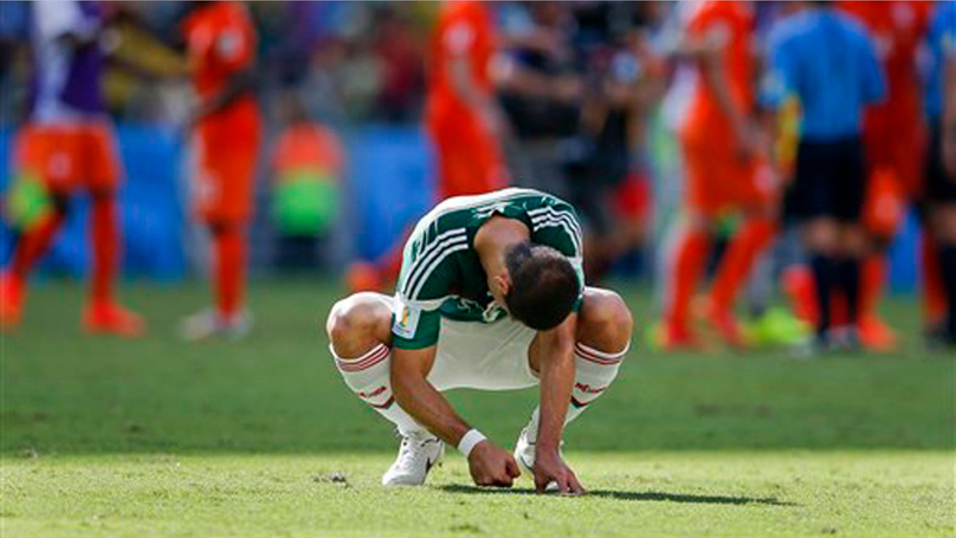 Mexico's Javier Hernandez punches the ground after the Netherlands defeated Mexico 2-1 to advance to the quarterfinals during the World Cup round of 16 soccer match between the Netherlands and Mexico at the Arena Castelao in Fortaleza, Brazil, Sunday, June 29, 2014. (AP Photo/Eduardo Verdugo)
