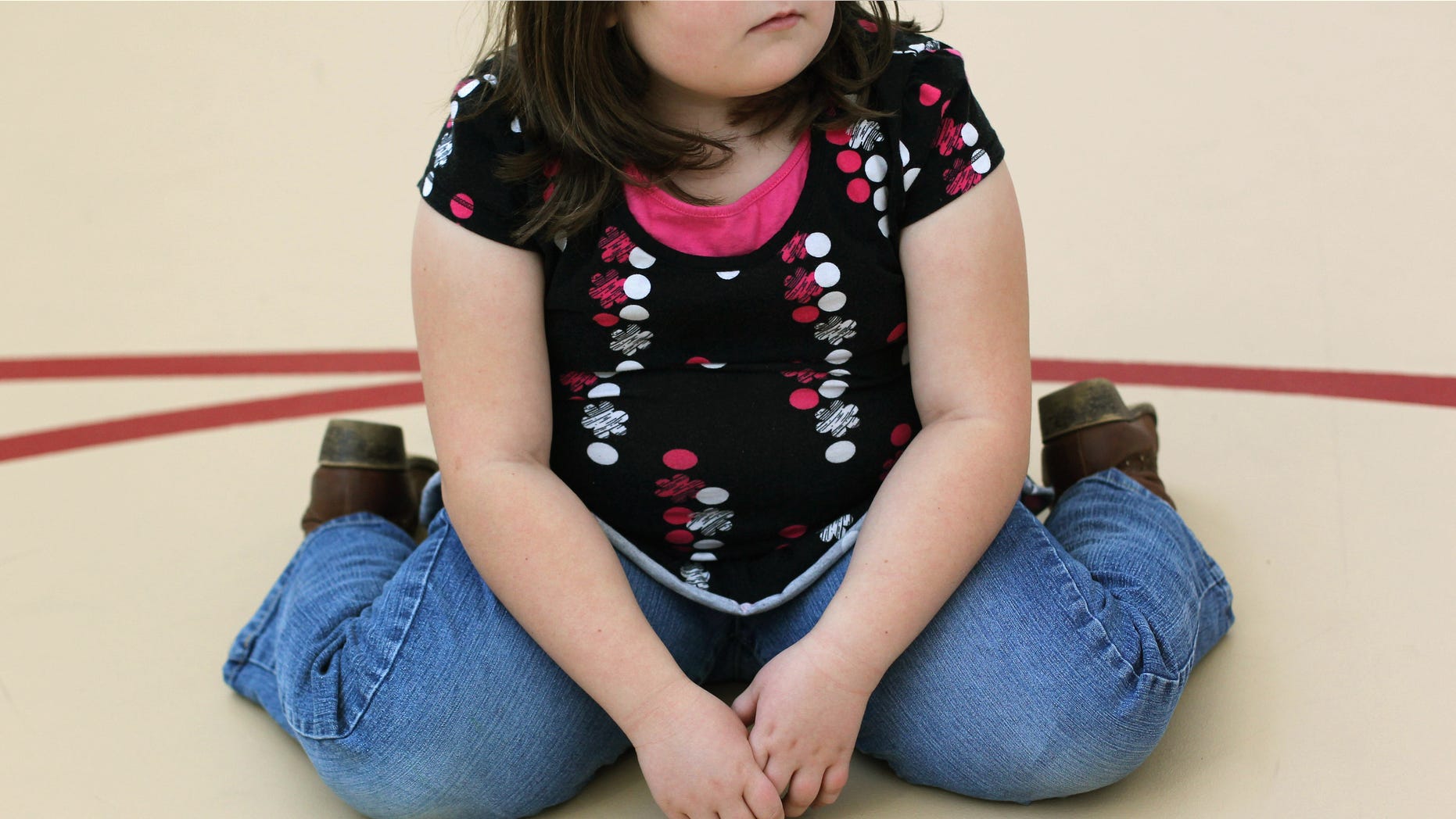 AURORA, CO - NOVEMBER 13: A child sits on the gym floor during the Shapedown program for overweight adolescents and children on November 13, 2010 in Aurora, Colorado. The 10-week family-centered program held by the Denver area Children's Hospital teaches youth and their parents ways to lead a healthier more active lifestyle, as a longer lasting weight-loss alternative to dieting. Nationally, some 15 percent of children are overweight or obese, as are some 60 percent of adults. (Photo by John Moore/Getty Images)