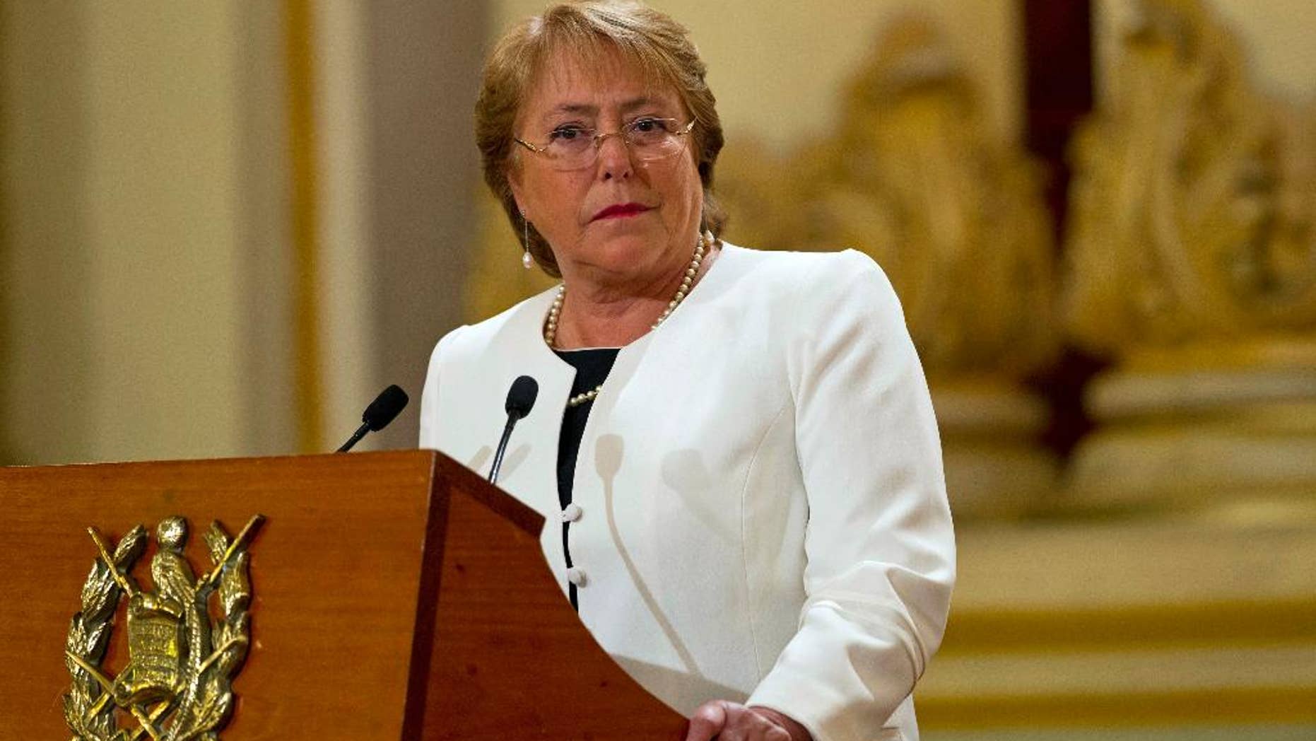 FILE - In this Friday, Jan. 30, 2015, file photo, Chile's President Michelle Bachelet listens to Guatemala's President Otto Perez Molina during their joint press conference at the National Palace in Guatemala City. President Bachelet has asked on Wednesday, May 6, 2015, for all her Cabinet ministers to submit their resignations. (AP Photo/Moises Castillo, File)