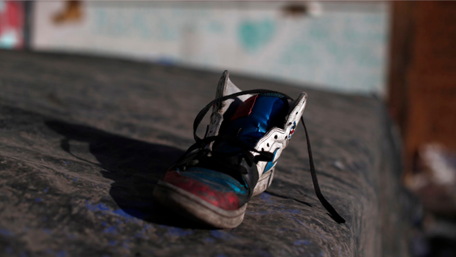 In this Oct. 10, 2016 photo, a discarded shoe lays on top a tarp used by street children for shelter in a ruined building in Santiago, Chile. Many if not all of the youths living in the ruin were once wards of the state, living in shelters of National Service for Minors. (AP Photo/Luis Hidalgo)