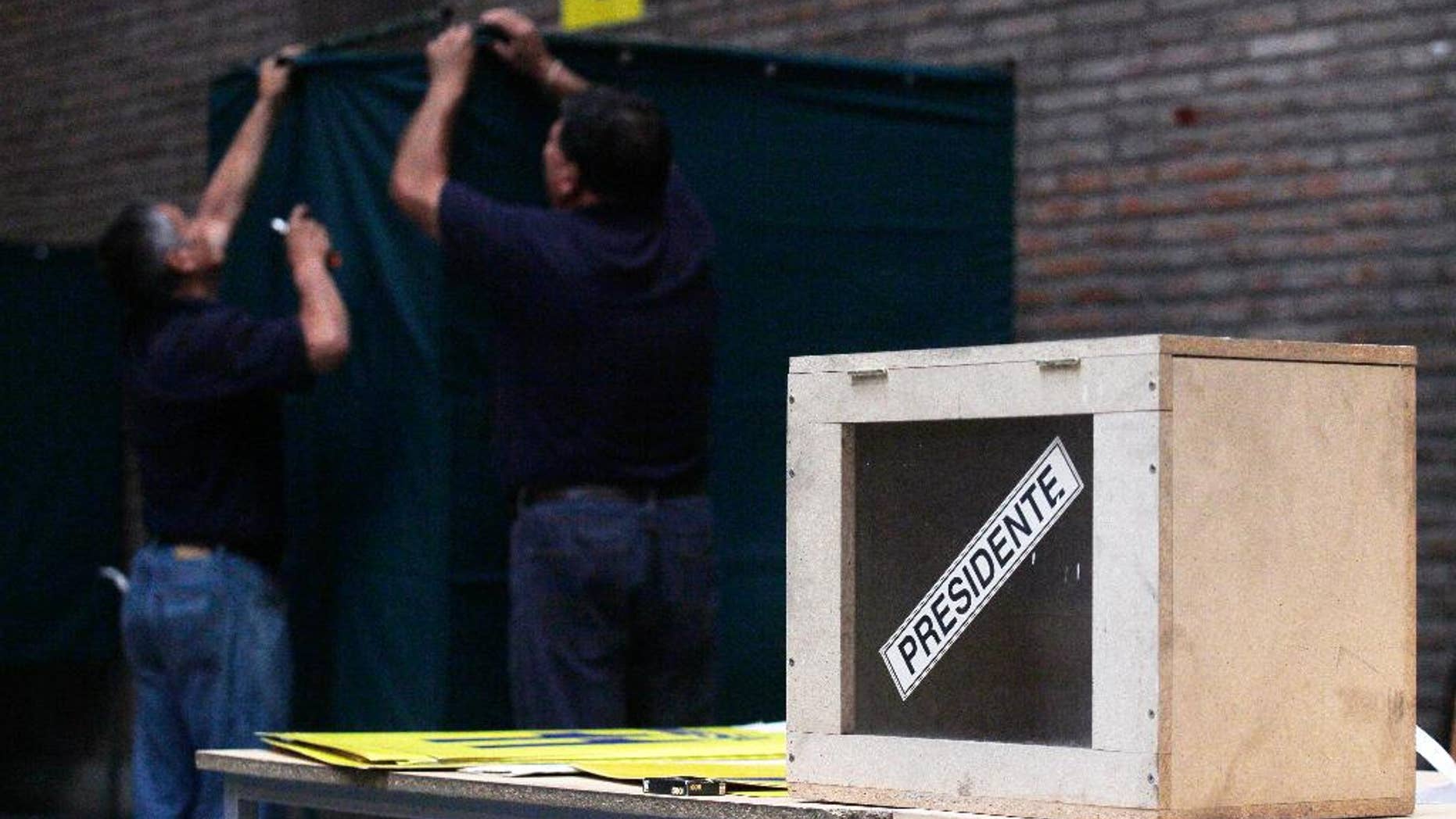 FILE - In this Dec. 14, 2013, file photo, workers set up a polling station at a school in Santiago, Chile. Chile has reformed its constitution, Tuesday April 22, 2014, to give voting rights to citizens living outside the country. The measure was more than 20 years in the making, and is seen as a major victory for the many Chileans who left the country during its long dictatorship. (AP Photo/Luis Hidalgo,File)