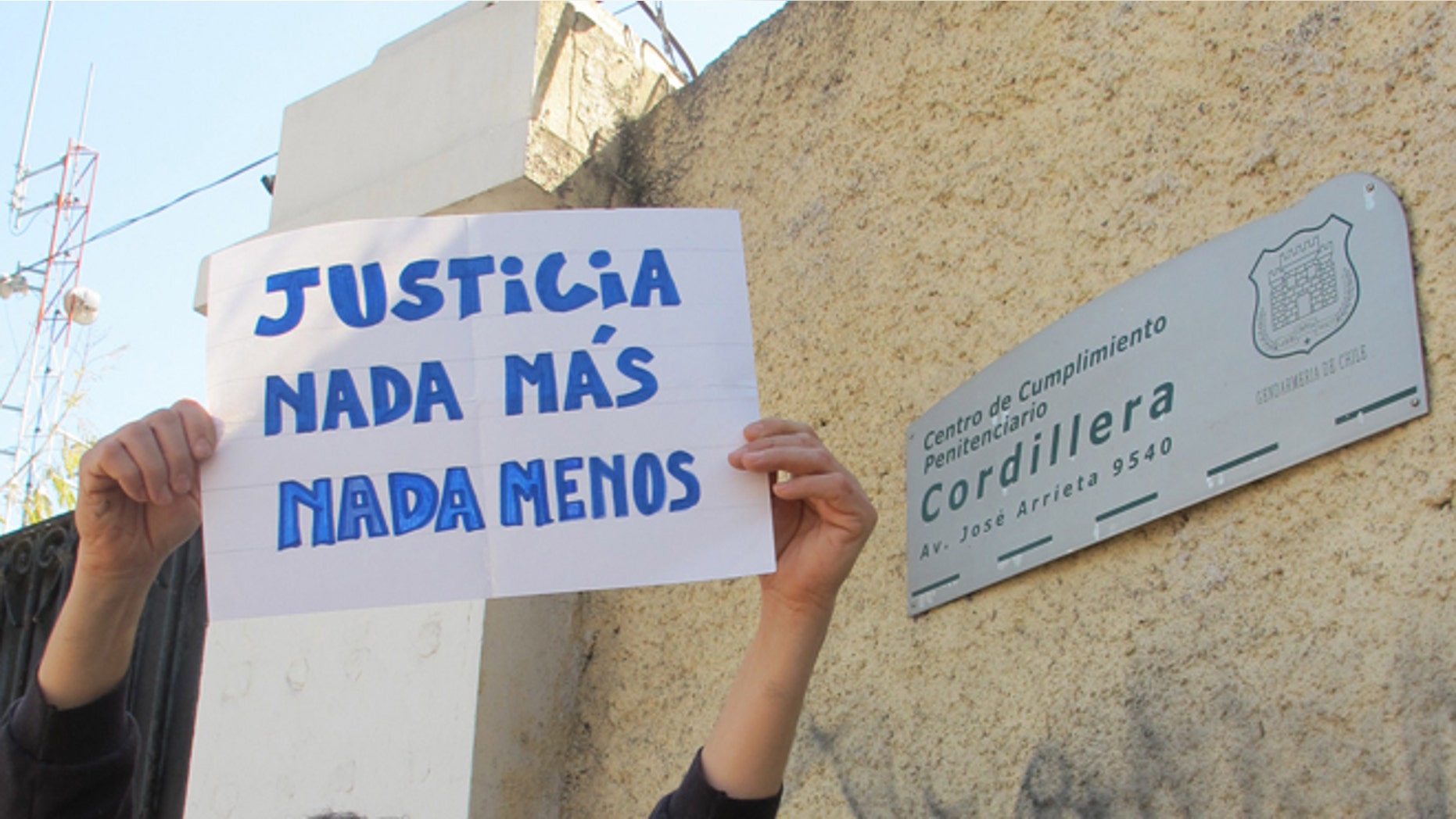 Claudio Escobar holds up a sign that reads in Spanish "Justice. Nothing more. Nothing less" at a demonstration organized by human rights activists outside the Cordillera prison in Santiago, Chile, Wednesday, Sept. 25, 2013. Chile's president announced Thursday that he will close the Cordillera prison, a luxury prison for dictatorship-era military officials convicted of crimes against humanity, taking away their tennis courts, barbecues and a pool. (AP Photo/Luis Andres Henao)