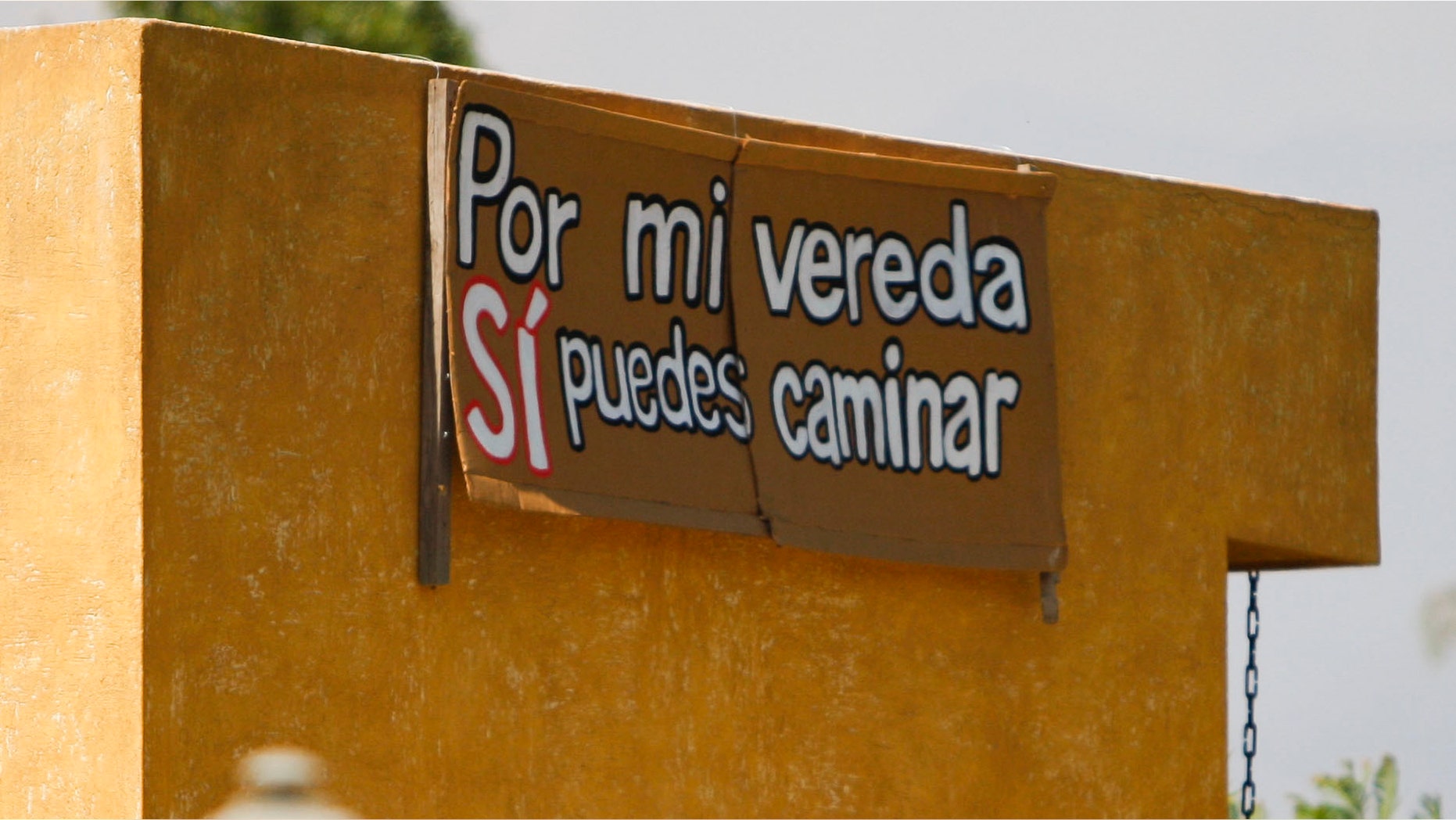 A sign that reads in Spanish "You can walk on my sidewalk"; hangs on a wall of a house at the gated community of El Algarrobal II in Chicureo, Chile, Thursday Jan. 19, 2012. According to community rules, workers are forbidden to walk along it. The refusal of Felicita Pinto, a maid who works at the neighborhood, to get on a bus to carry her to her workplace, just a short walk away, has set off a soul-searching debate about class prejudice and exploitation in Chile and prompted a protest Saturday against discrimination. (AP Photo/Roberto Candia)