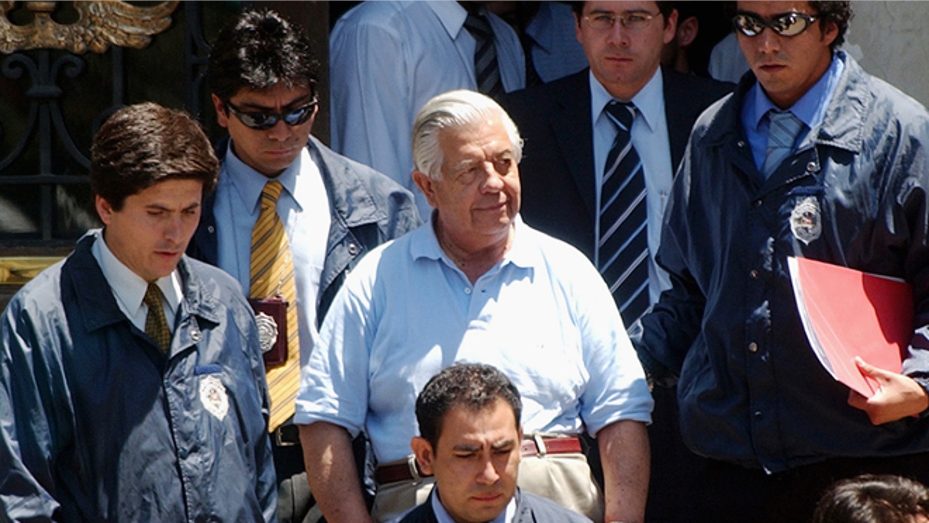 FILE.- In this Jan. 28, 2005 file photo retired Gen. Manuel Contreras, center, is escorted by police officers in Santiago, Chile. According to Chile's government, Contreras, the former chief of Chile's spy agency responsible for the kidnapping and torture of thousands during the Pinochet military dictatorship died Friday in Santiago's military hospital. He was 86.(AP Photo, File)