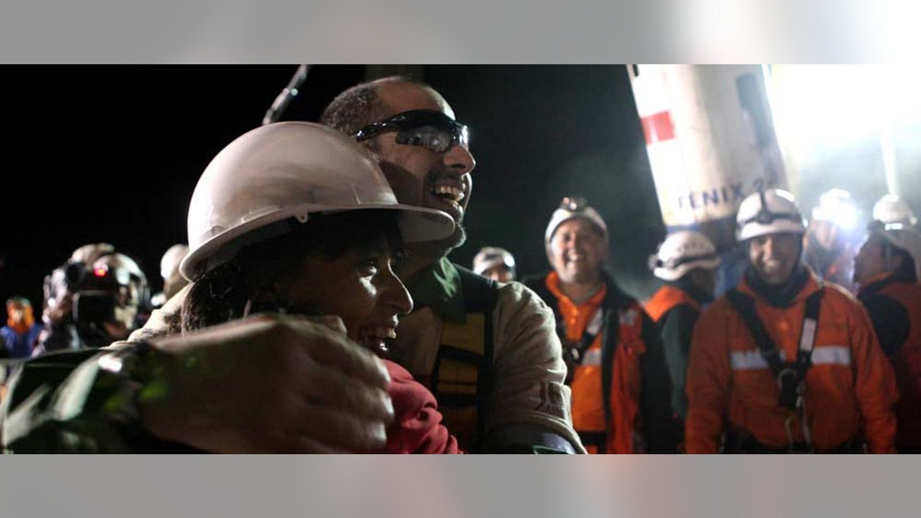 In this photo released by the Chilean government, miner Mario Sepulveda, right, is hugged by an unidentified relative after being rescued from the collapsed San Jose gold and copper mine where he was trapped with 32 other miners for over two months near Copiapo, Chile, early Wednesday, Oct. 13, 2010. (AP Photo/Hugo Infante, Chilean government)