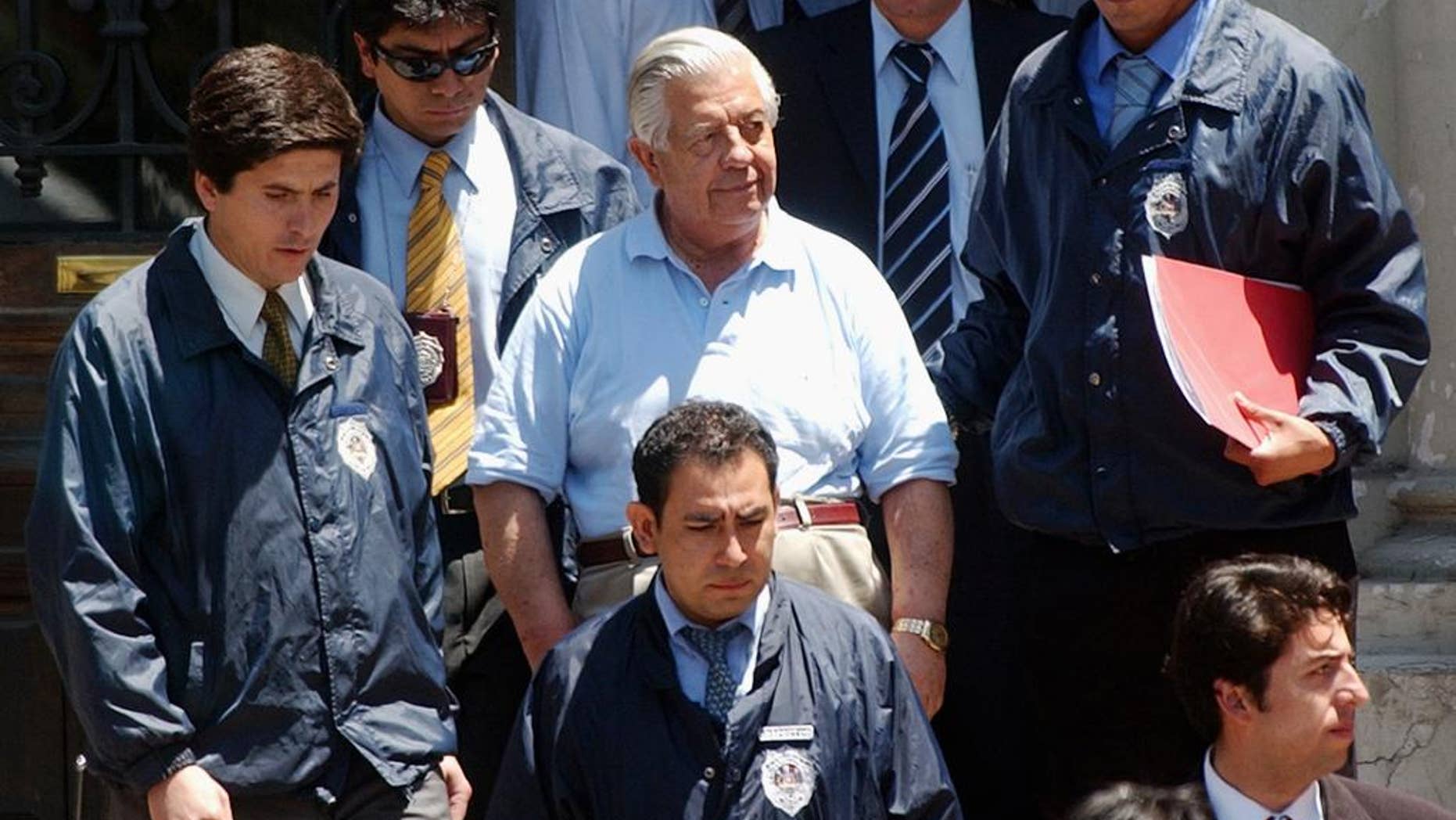 FILE.- In this Jan. 28, 2005 file photo retired Gen. Manuel Contreras, center, is escorted by police officers in Santiago, Chile. According to Chile's government, Contreras, the former chief of Chile's spy agency responsible for the kidnapping and torture of thousands during the Pinochet military dictatorship died Friday in Santiago's military hospital. He was 86.(AP Photo, File)