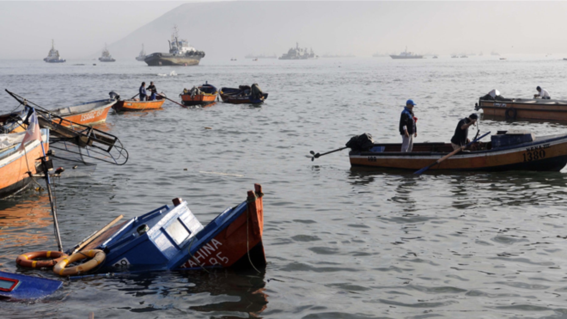 Fishing boats lie damaged by a small tsunami, in the northern town of Iquique, Chile, after magnitude 8.2 earthqauke struck the northen coast of Chile, Wednesday, April 2, 2014. Authorities lifted tsunami warnings for Chiles long coastline early Wednesday. Six people were crushed to death or suffered fatal heart attacks, a remarkably low toll for such a powerful shift in the Earths crust. (AP Photo/Cristian Viveros) NO PUBLICAR EN CHILE