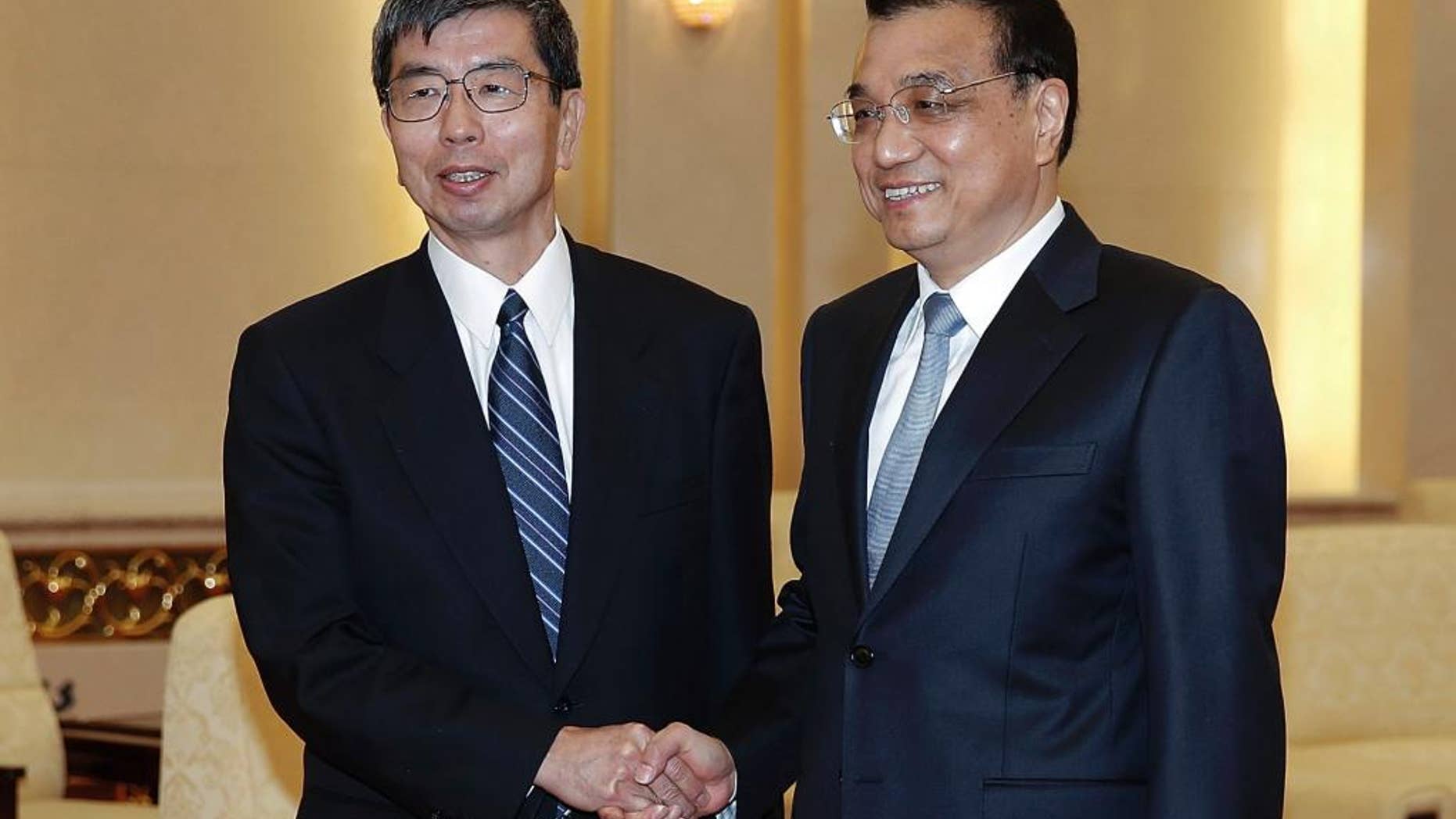 FILE - In this March 23, 2015 file photo, Asian Development Bank President Takehiko Nakao, left, poses with Chinese Premier Li Keqiang for a photo at the Great Hall of the People in Beijing. The president of the Asian Development Bank says a proposed Chinese-led regional bank is a potential partner instead of a rival and the ADB is talking with Beijing to share its experience. (AP Photo/Lintao Zhang, Pool, File)