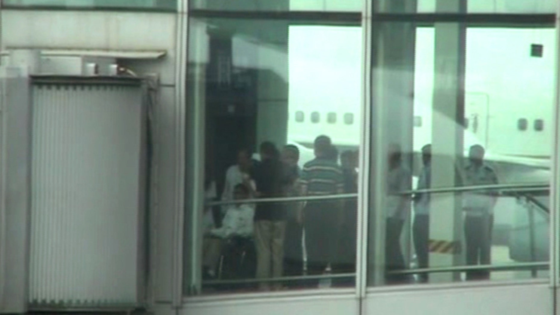 May 19, 2012: Blind Chinese activist Chen Guangcheng, left, pushed in a wheelchair from an elevator to a sky bridge that is connected to a plane at Beijing International airport.