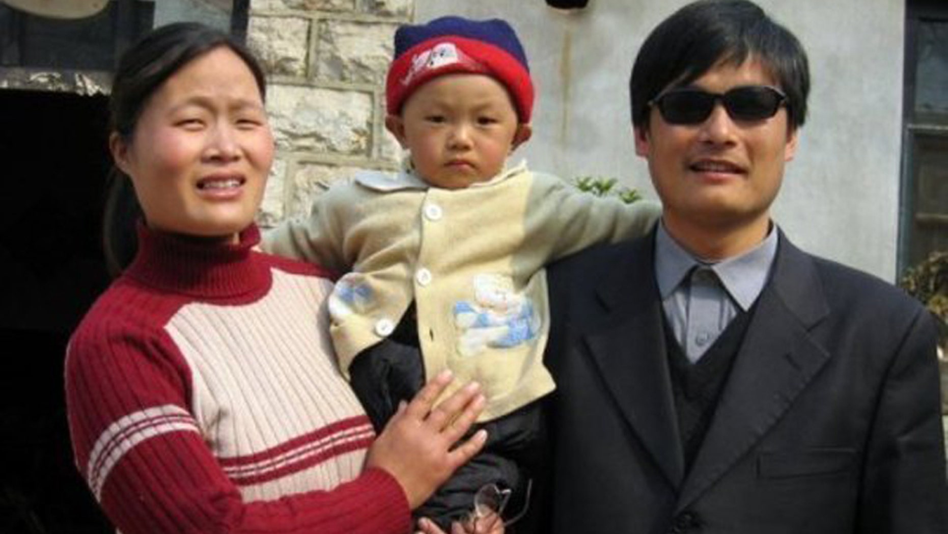 This undated photo provided by the China Aid Association shows blind Chinese legal activist Chen Guangchen, right, with his son, Chen Kerui, with his wife Yuan Weijing, left, in Shandong province, China.