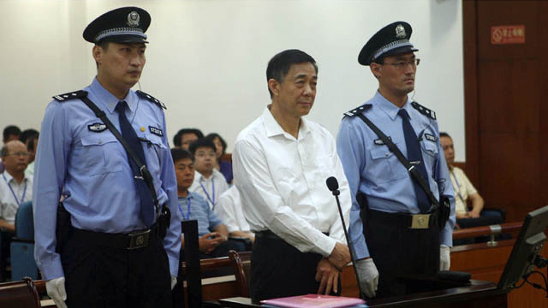 FILE - In this Aug. 22, 2013 file photo released by the Jinan Intermediate People's Court, former Politburo member and Chongqing city party leader Bo Xilai, center, stands on trial at the court in eastern China's Shandong province. (AP Photo)