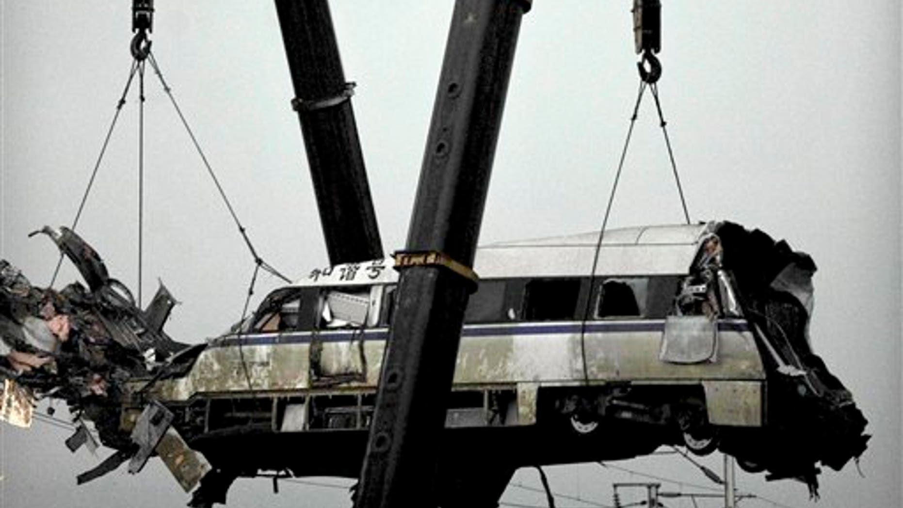 July 24, 2011: A wrecked passenger carriage is lifted off the bridge in Wenzhou in east China's Zhejiang province, after a train crash.