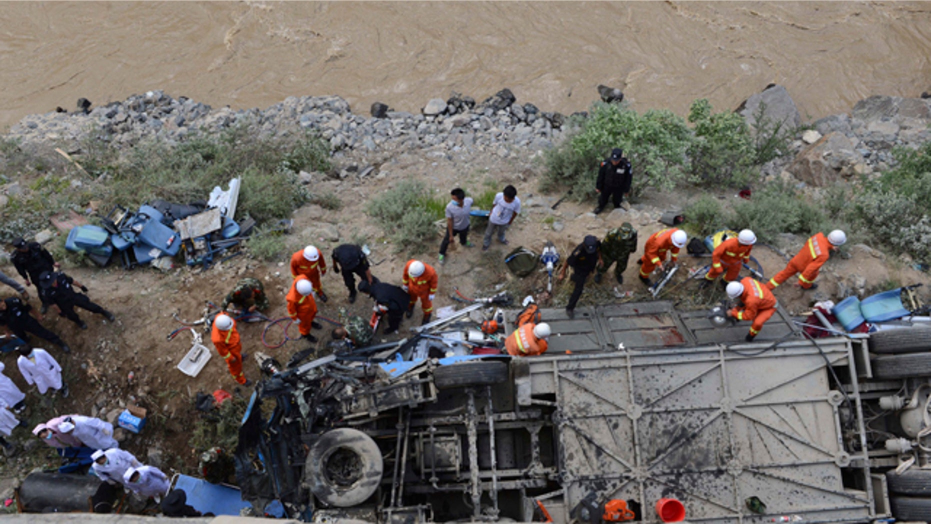 August 9, 2014: In this photo released by China's Xinhua News Agency, rescuers work around an overturned tour bus after it fell off a 30-foot cliff in Nyemo County in southwest China's mountainous region of Tibet. (AP Photo/Xinhua, Chogo).