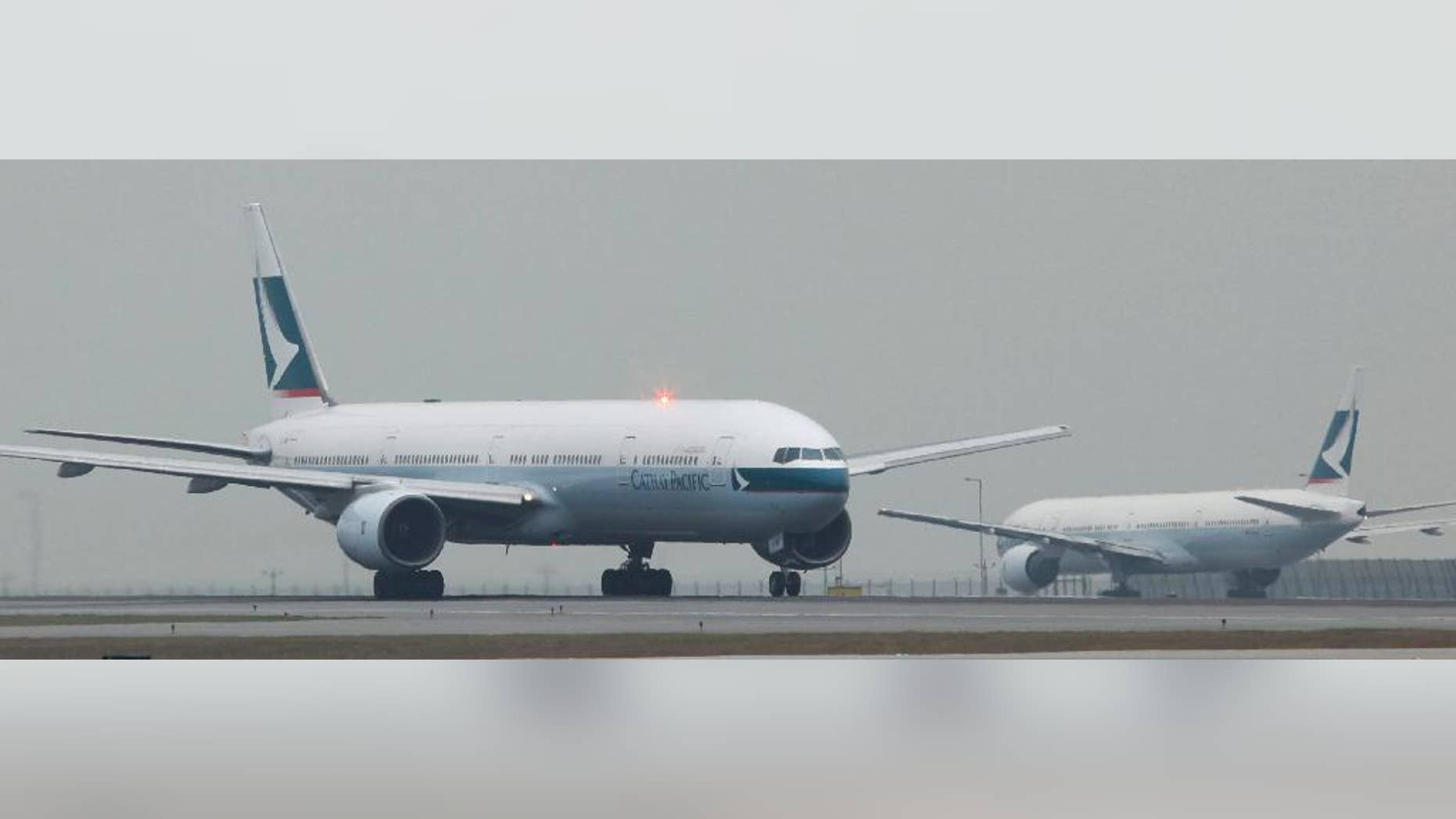 FILE - In this March 8, 2011 file photo, Cathay Pacific Airways planes queue up for departure at the Hong Kong Airport in Hong Kong. Chinese authorities say Cathay Pacific flight 831 from New York to Hong Kong was stranded for more than 16 hours in Zhuhai, China Sunday March 30, 2014 because of a hail storm and limits on the crew's work hours. (AP Photo/Kin Cheung)