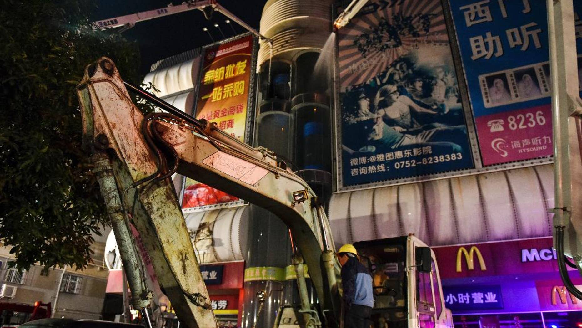 In this Thursday, Feb. 5, 2015 photo released by China's Xinhua News Agency, fire fighters try to extinguish a fire at a wholesale market in Huidong County, southern Guangdong province, China. A 9-year-old boy playing with a lighter caused a fire at the southern China wholesale market killed more than a dozen people, officials said Saturday. (AP Photo/Xinhua, Mao Siqian) NO SALES