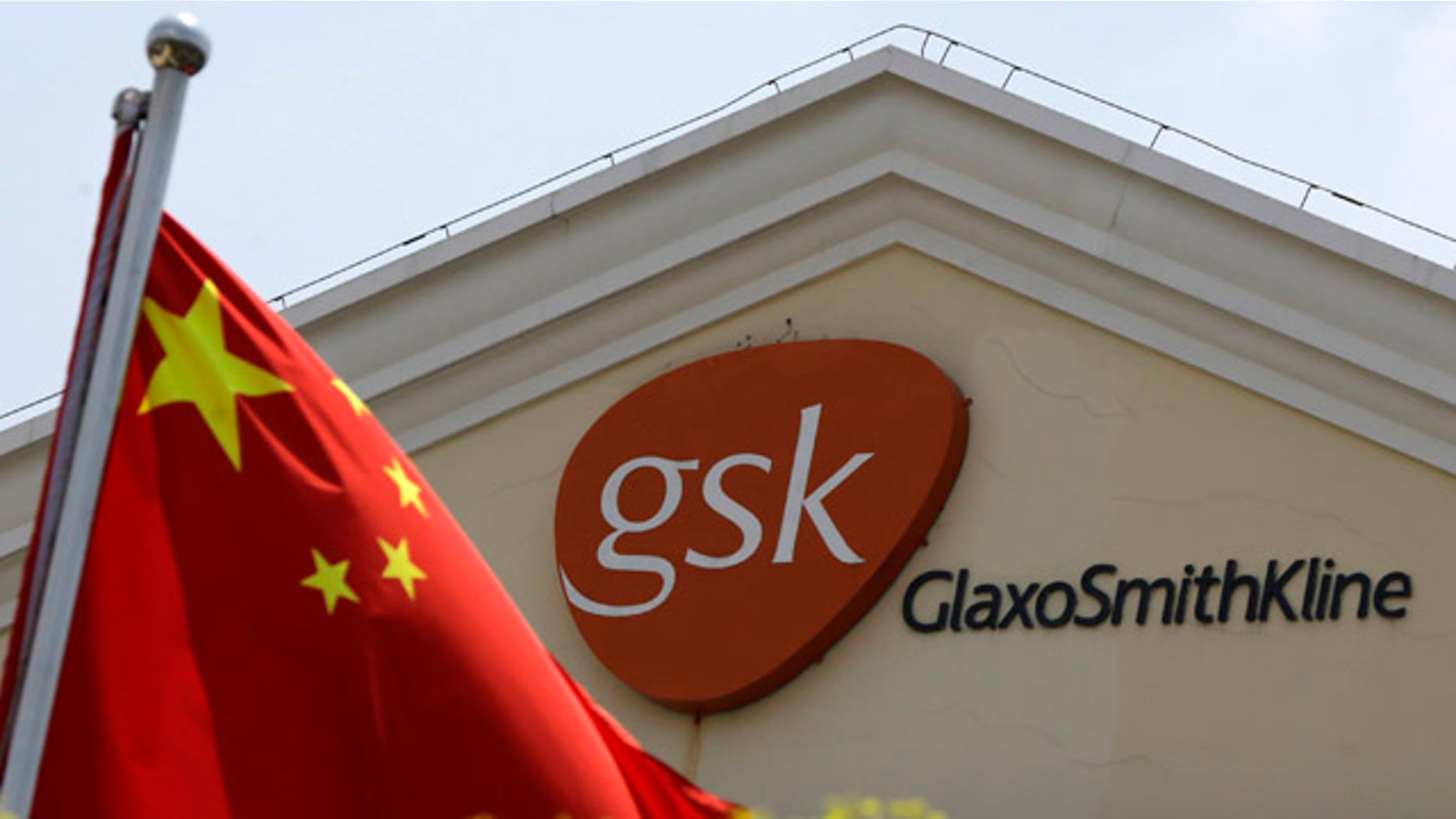 July 24, 2013: A Chinese flag is hoisted in front of a GlaxoSmithKline building in Shanghai, China. (AP Photo/Eugene Hoshiko, File)