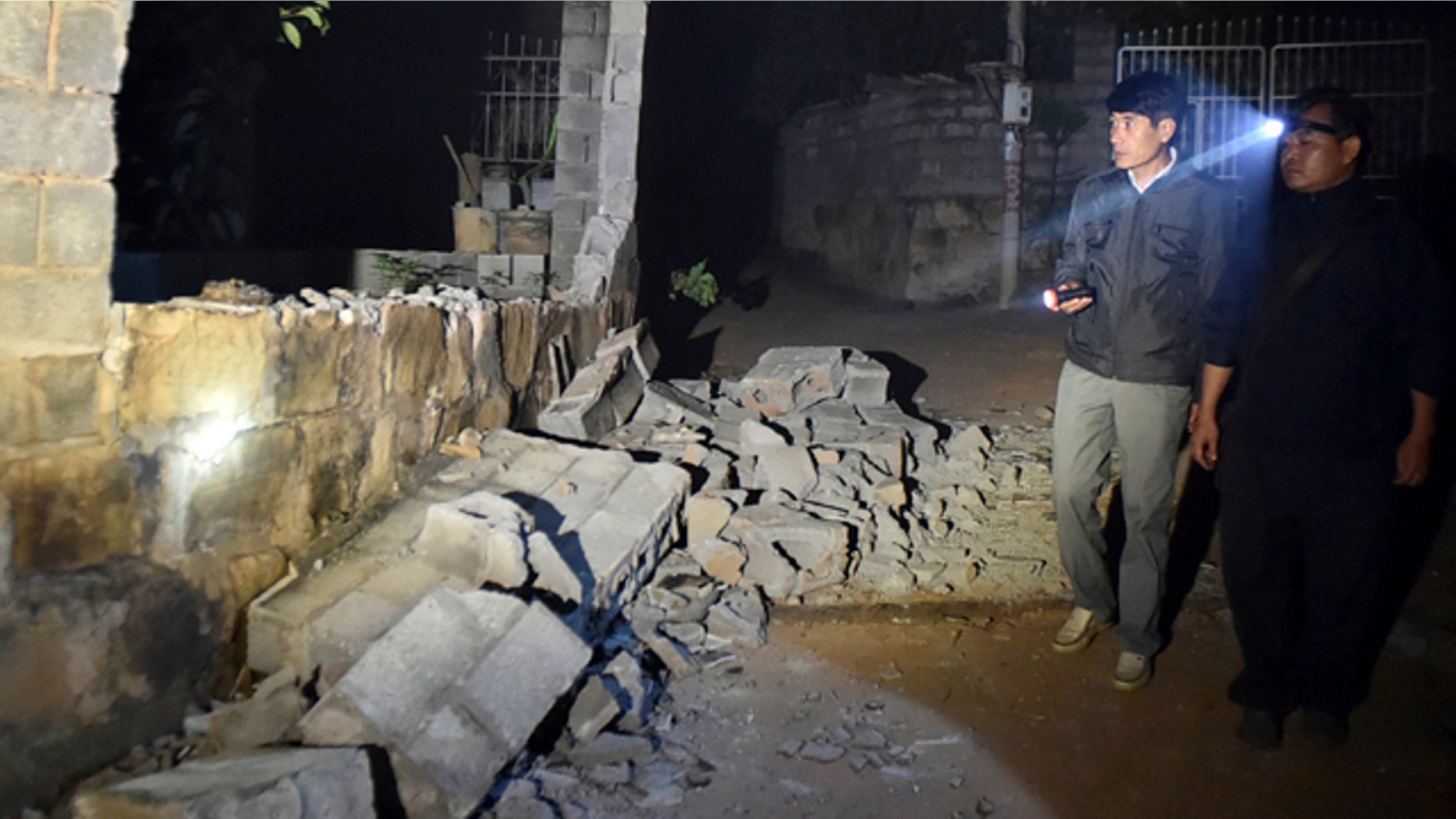 October 8, 2014: In this photo released by China's Xinhua News Agency, villagers check a damaged house at Mangla Village of Yongping Township at Jinggu County of Pu'er City, southwest China's Yunnan Province. (AP Photo/Xinhua, Chen Haining)