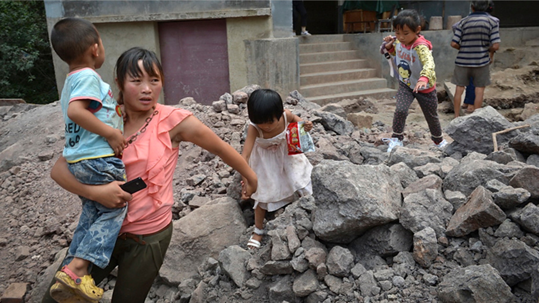 Sept. 8, 2012: A woman brings the children evacuate from an earthquake hit Luozehe town in Yiliang county in southwest China's Yunnan province.