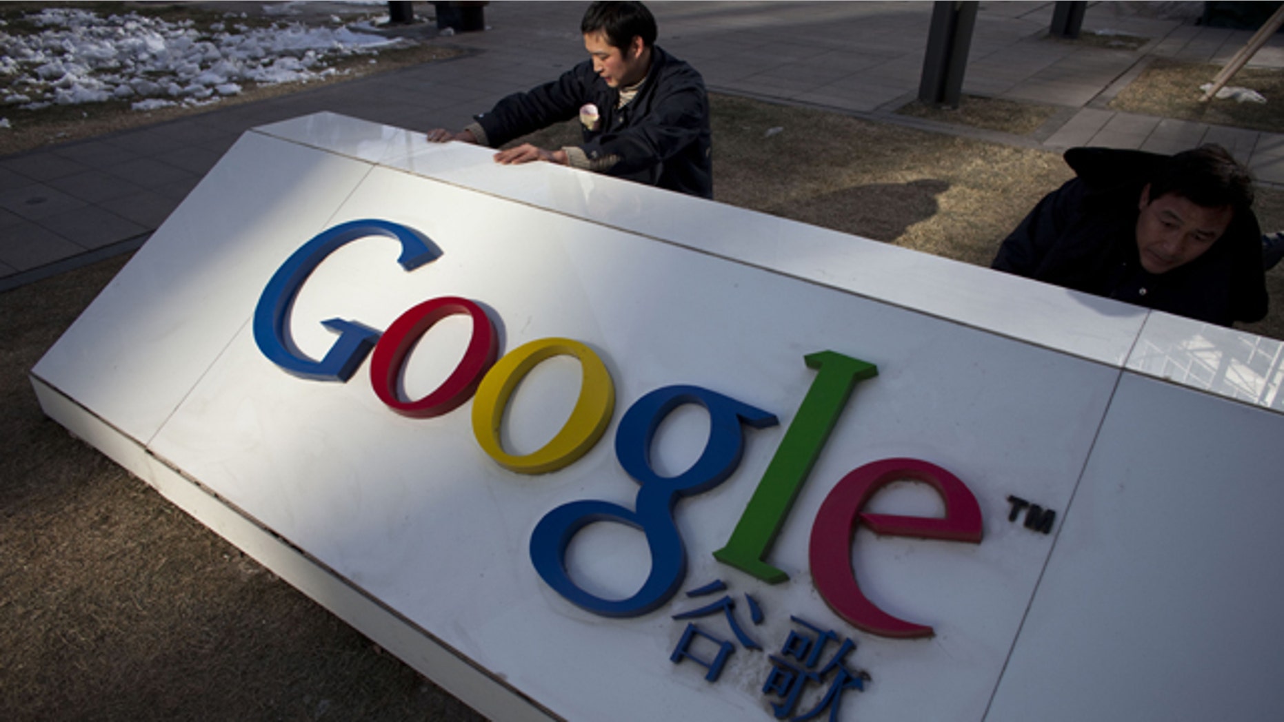 Workers repair a partially broken marble tablet which bears Google's logo in front of Google China's headquarters building in Beijing, China.