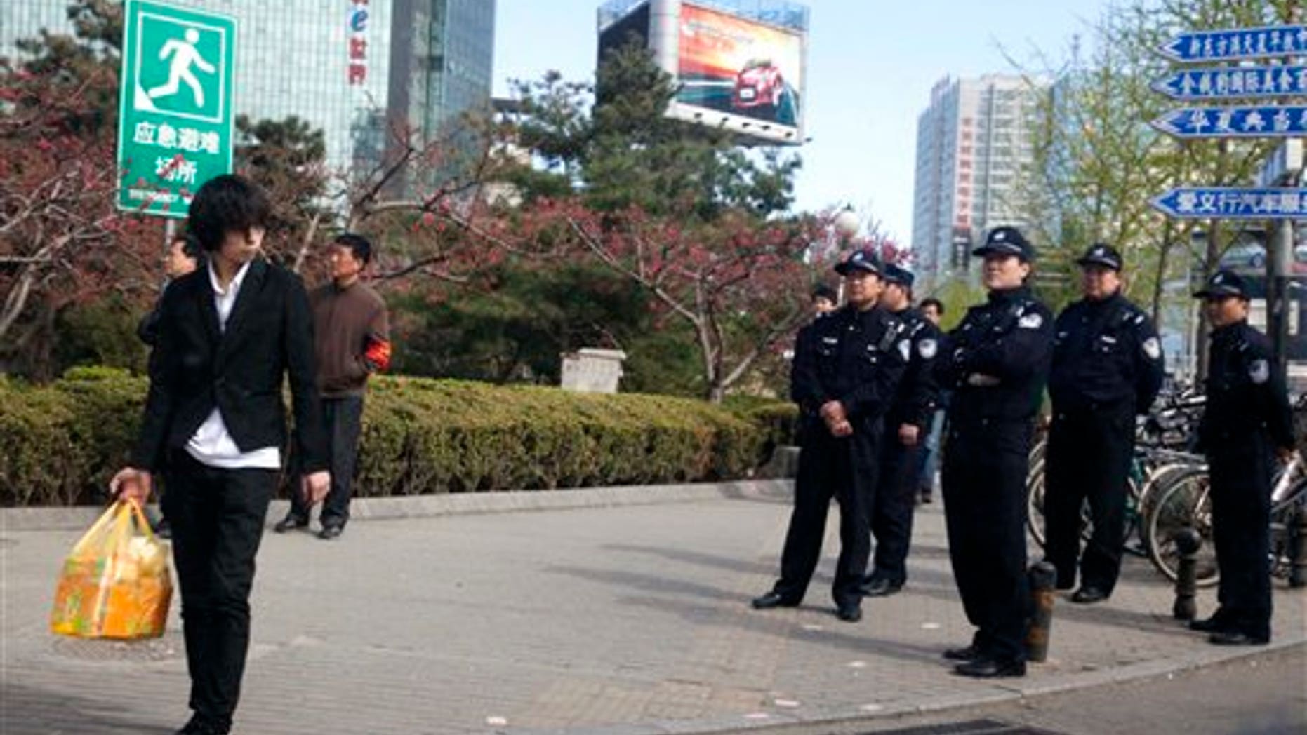 April 10: Chinese police officers watch an area near a building that leaders of the unregistered Shouwang house church had told parishioners to gather in Beijing, China. Beijing police on Sunday detained at least a dozen worshippers from the Christian house church who were trying to hold services in a public space after they were evicted from their usual place of worship. (AP)