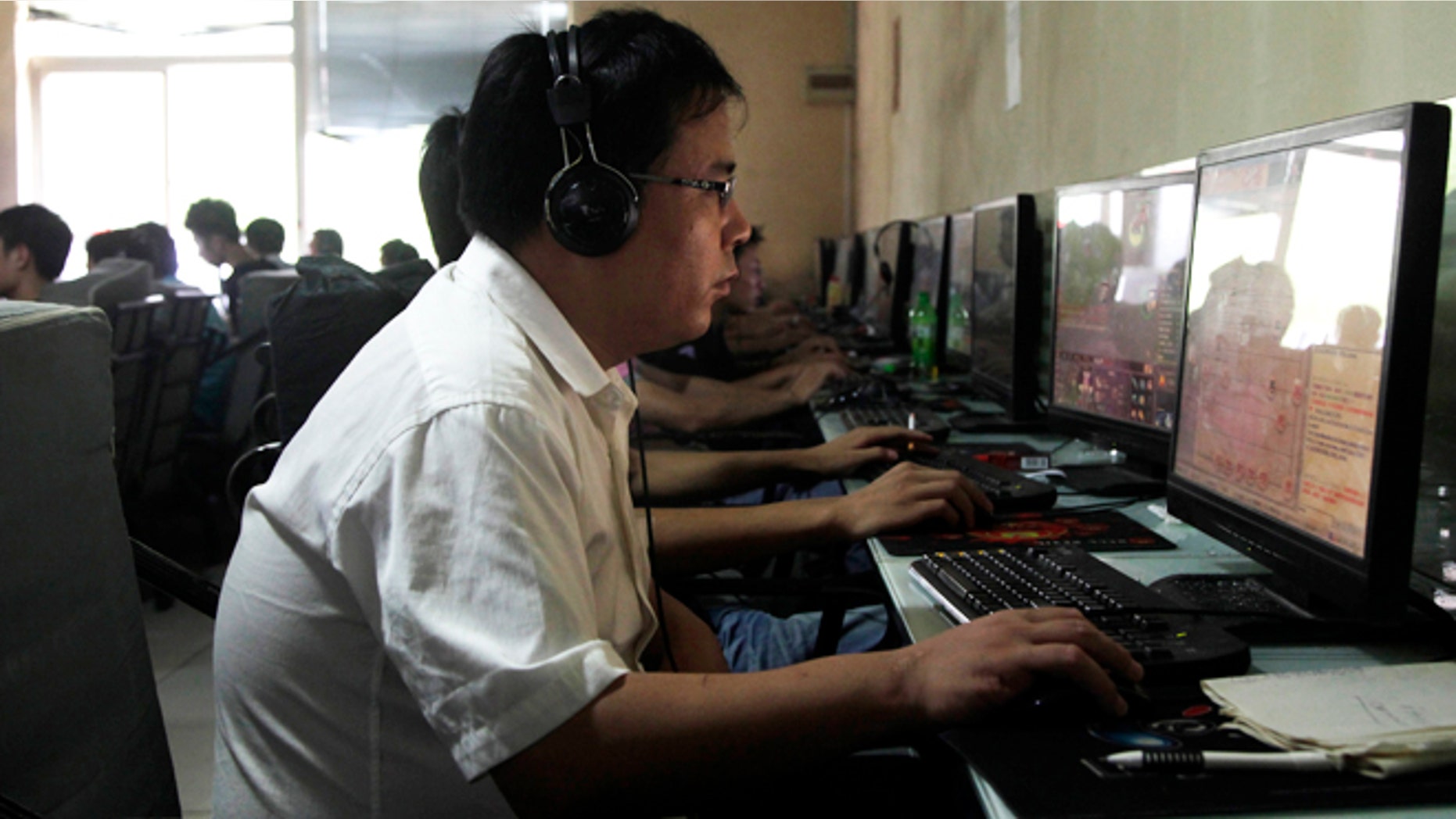 July 14, 2010: A Chinese man uses a computer at an Internet cafe in Beijing. China's new communist leaders are increasing already tight controls on Internet use and electronic publishing following a spate of embarrassing online reports about official abuses.