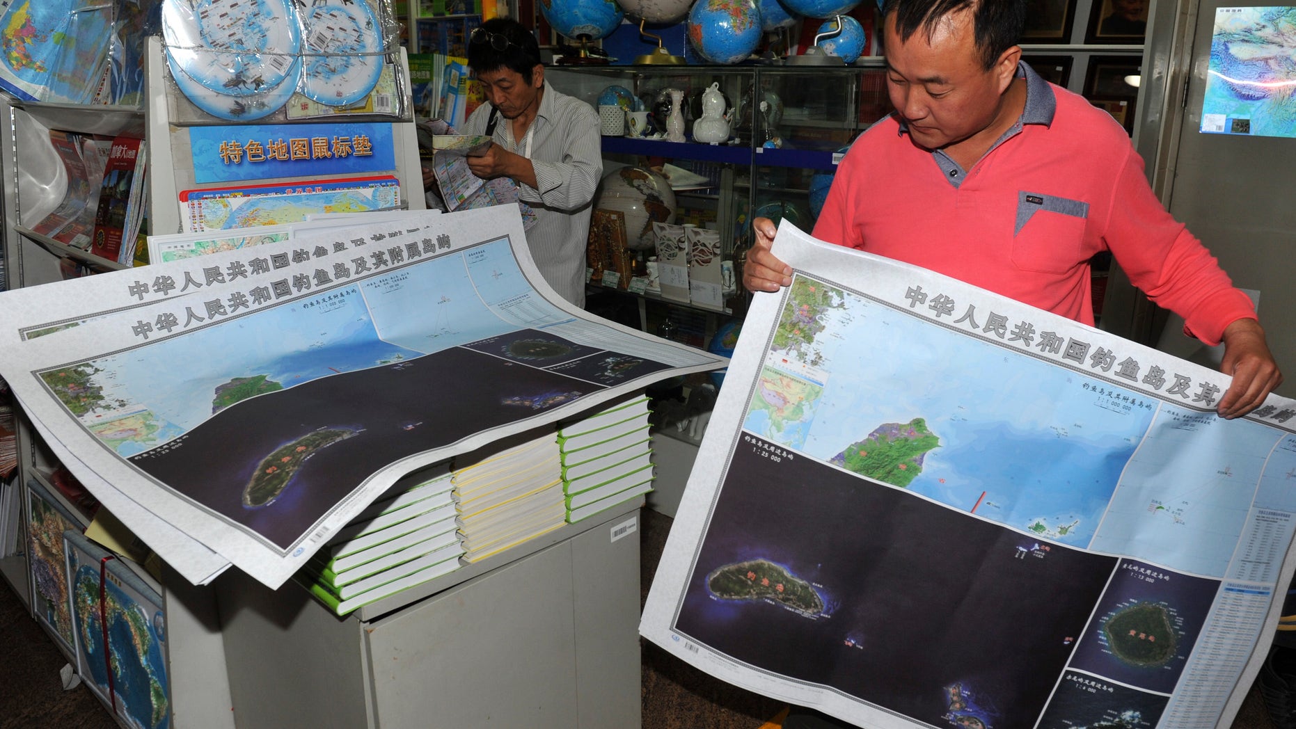 Sept. 19, 2012: In this photo, a costumer picks copies of newly-published maps of disputed islands, called Diaoyu in China and Senkaku in Japan, at a state-owned book store in Beijing, China.