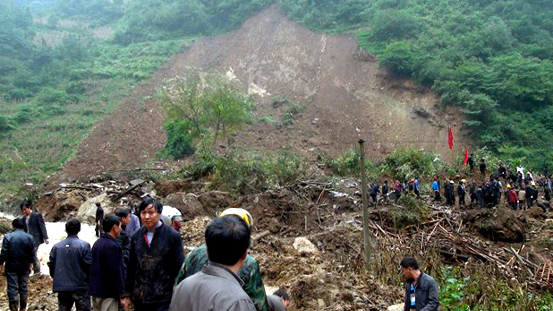 In this photo taken Thursday Oct. 4, 2012, residents gather at a landslide in Yiliang county in southwest China's Yunnan province. All 18 elementary school students buried in the landslide were confirmed dead Friday, while one other person remained missing a day after the hillside collapsed and smothered part of a village in mountainous southwestern China. (AP Photo) CHINA OUT
