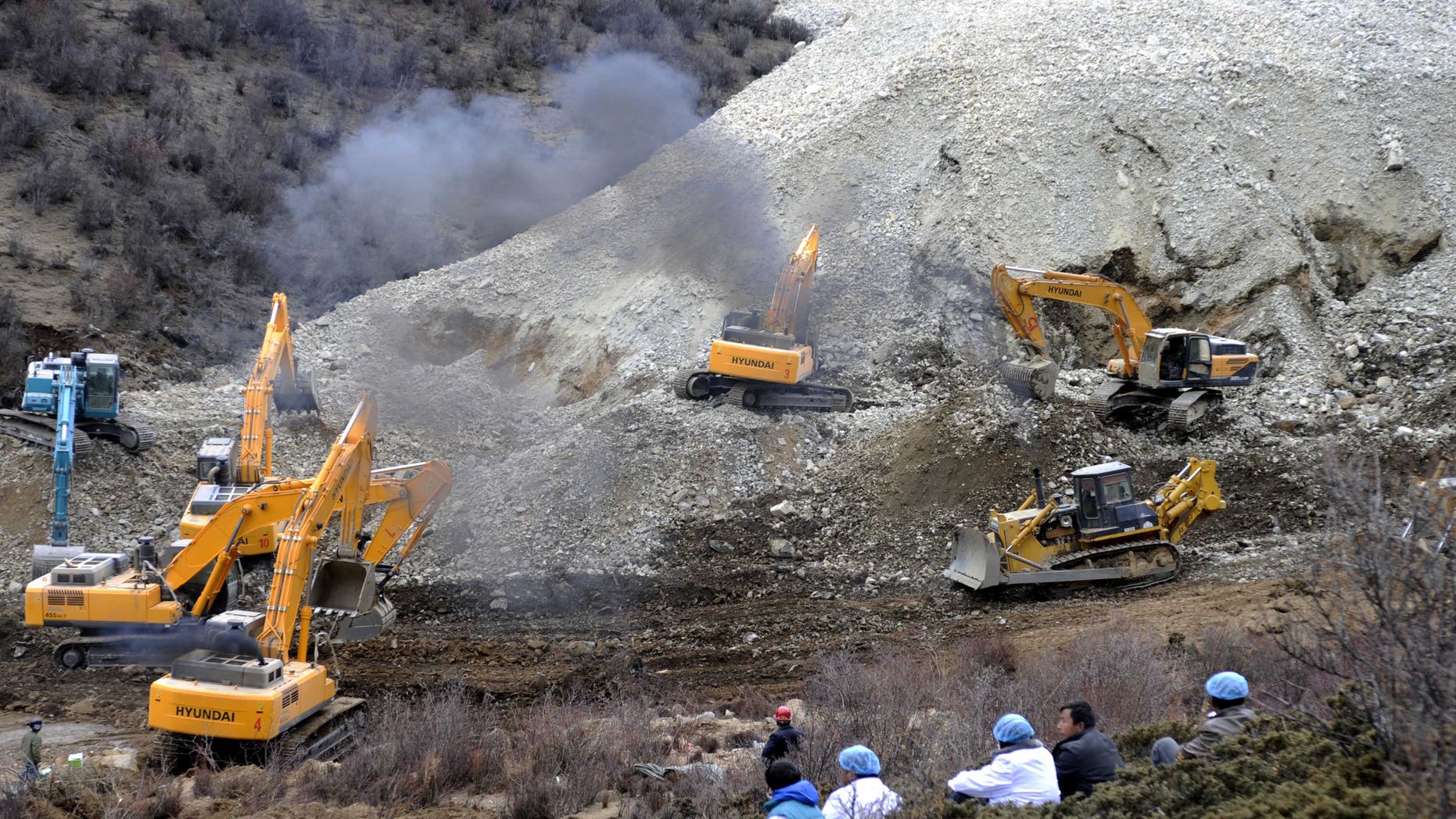 March 29, 2013 - Earthmovers remove rocks and mud on the scene where a landslide hit a mining area in Maizhokunggar County of Lhasa, southwest China's Tibet Autonomous Region.