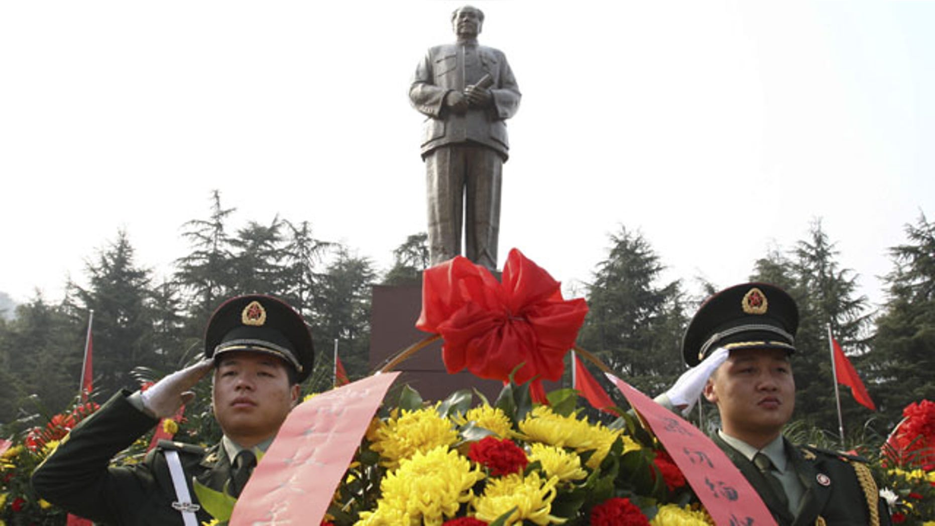 December 25, 2013: Security guards salute near wreaths in front of a statue of the late Communist leader Mao Zedong in Shaoshan, Mao's hometown, in southern China's Hunan province. (AP Photo)