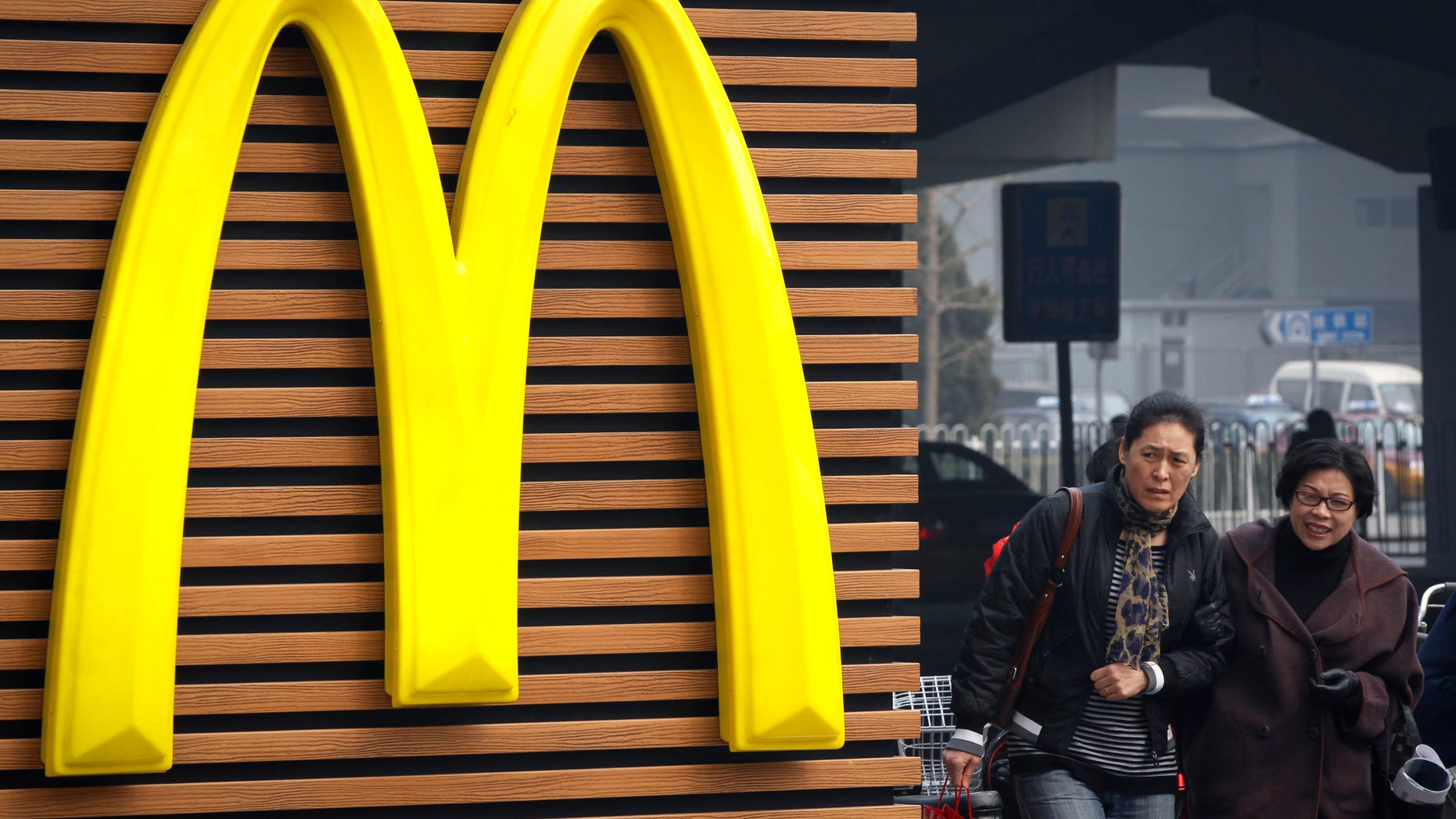 Mar. 16, 2012: Chinese women walk past a McDonald's sign in Beijing.