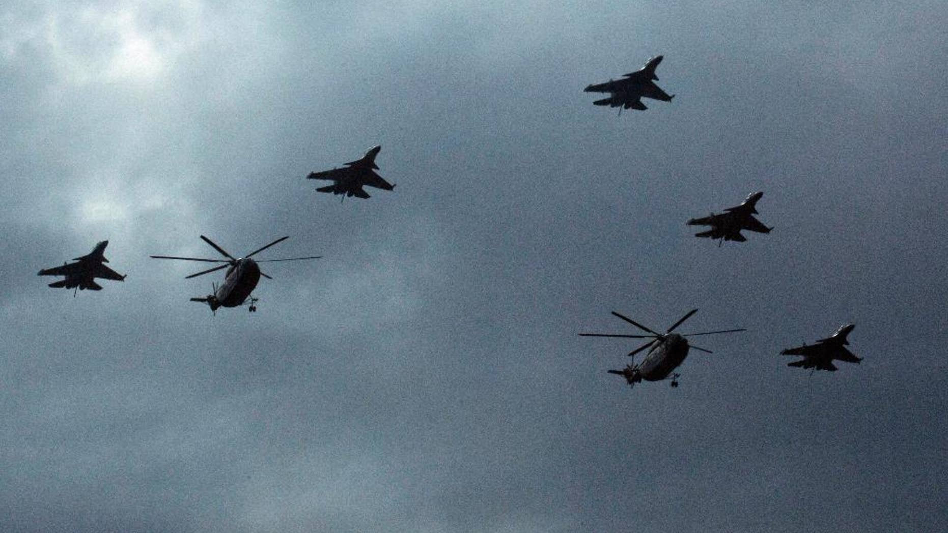 Chinese military helicopters and fighter jets take part in rehearsals ahead of the Sept. 3 military parade to commemorate the end of World War II in Beijing, Sunday, Aug. 23, 2015. China is ramping up publicity for its upcoming massive military parade but officials still aren't saying what other countries are taking part. (AP Photo/Ng Han Guan)