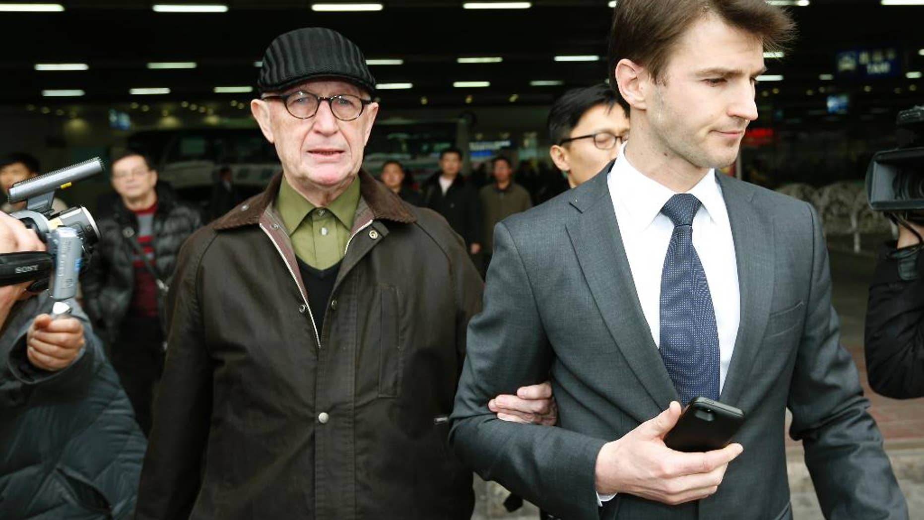 Australian missionary John Short, left, walks out from the airport terminal as he arrives at Beijing International Airport in Beijing, China, Monday, March 3, 2014. Short was deported from North Korea after he was detained for spreading Christianity in the country and apologized for his anti-state religious acts and requested forgiveness. (AP Photo/Vincent Thian)