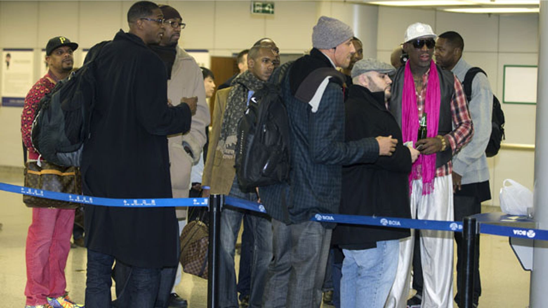 January 6, 2014: Former NBA basketball player Dennis Rodman, right, and former NBA players wait at the departure hall of Beijing International Capital Airport. Rodman says he's going forward with an exhibition game including former NBA players in North Korea because he wants to connect with its people and let others know the sheltered communist country isn't so bad. (AP Photo/Andy Wong)