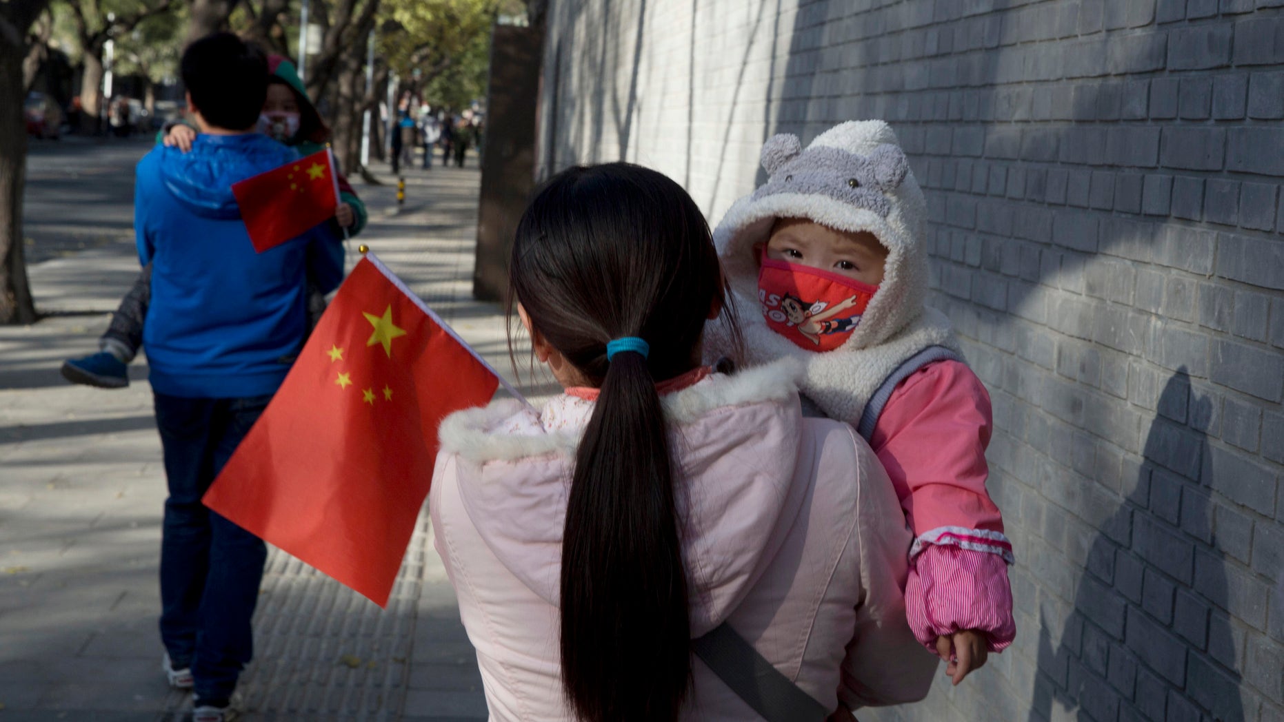 Nov. 16. 2013: Visitors to the forbidden city carry children holding the Chinese national flags in Beijing, China.
