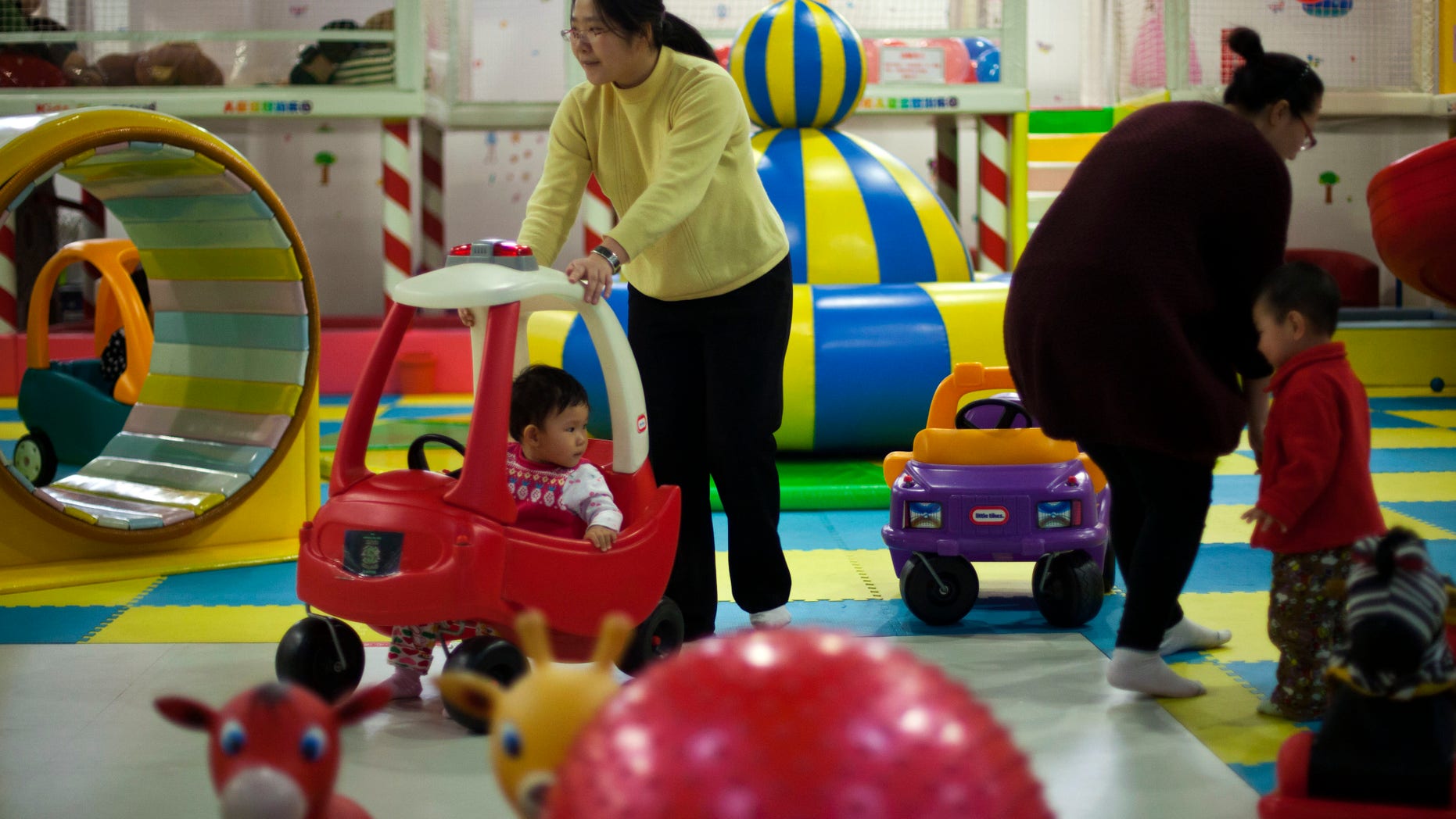 Jan. 10, 2013 - FILE photo of parents playing with their children at a shopping mall in Beijing. China will loosen its decades-old one-child policy and abolish a much-criticized labor camp system, its ruling Communist Party said. Friday,