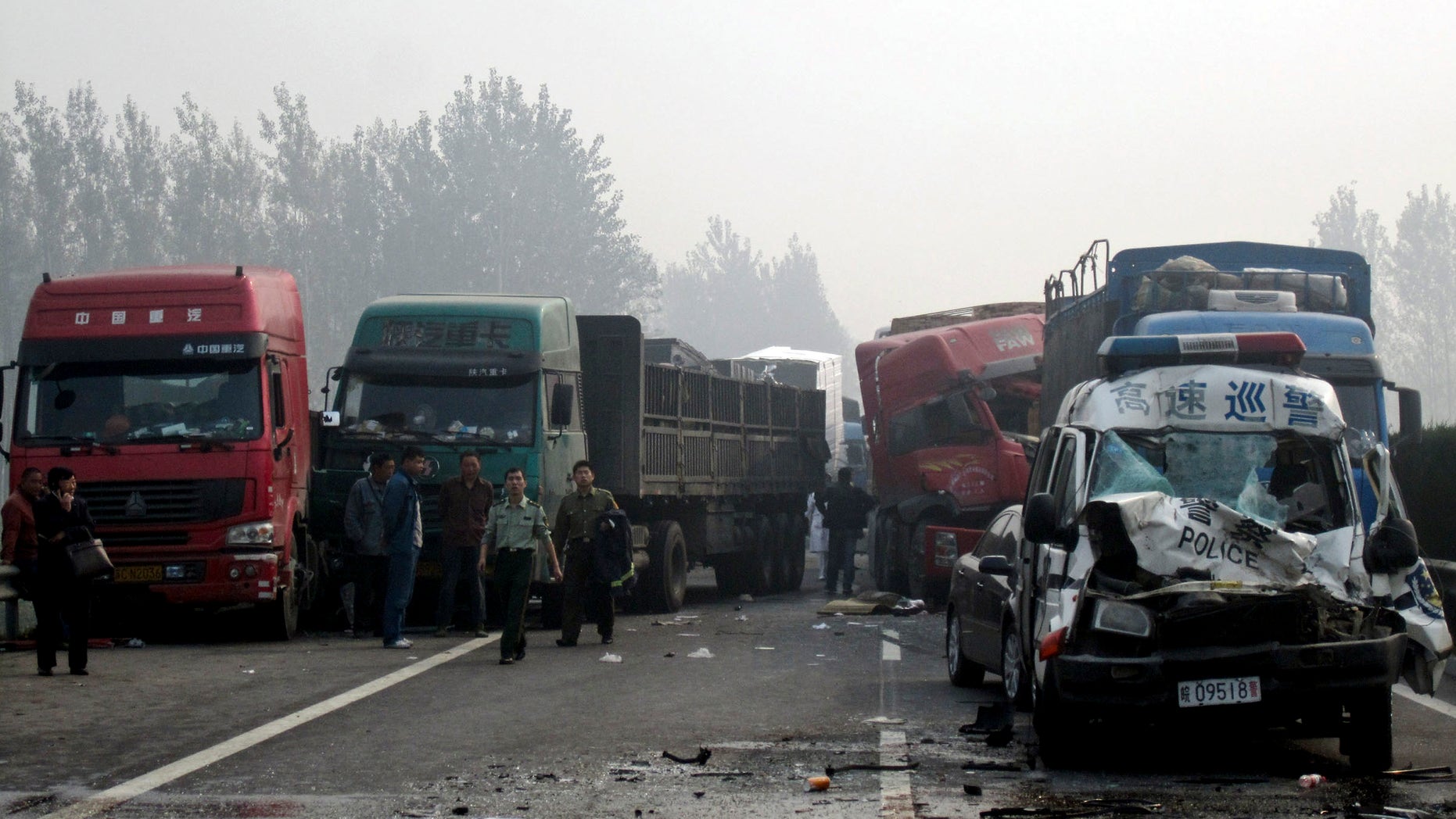 Oct. 7, 2011: People look at the damaged vehicles piled up on a highway road in Huaibei in central China's Anhui province. Three major road accidents in China killed at least 56 people on the last day of a weeklong holiday, including 35 people who died after a bus collided with a car on a northern expressway, state media reported Saturday.