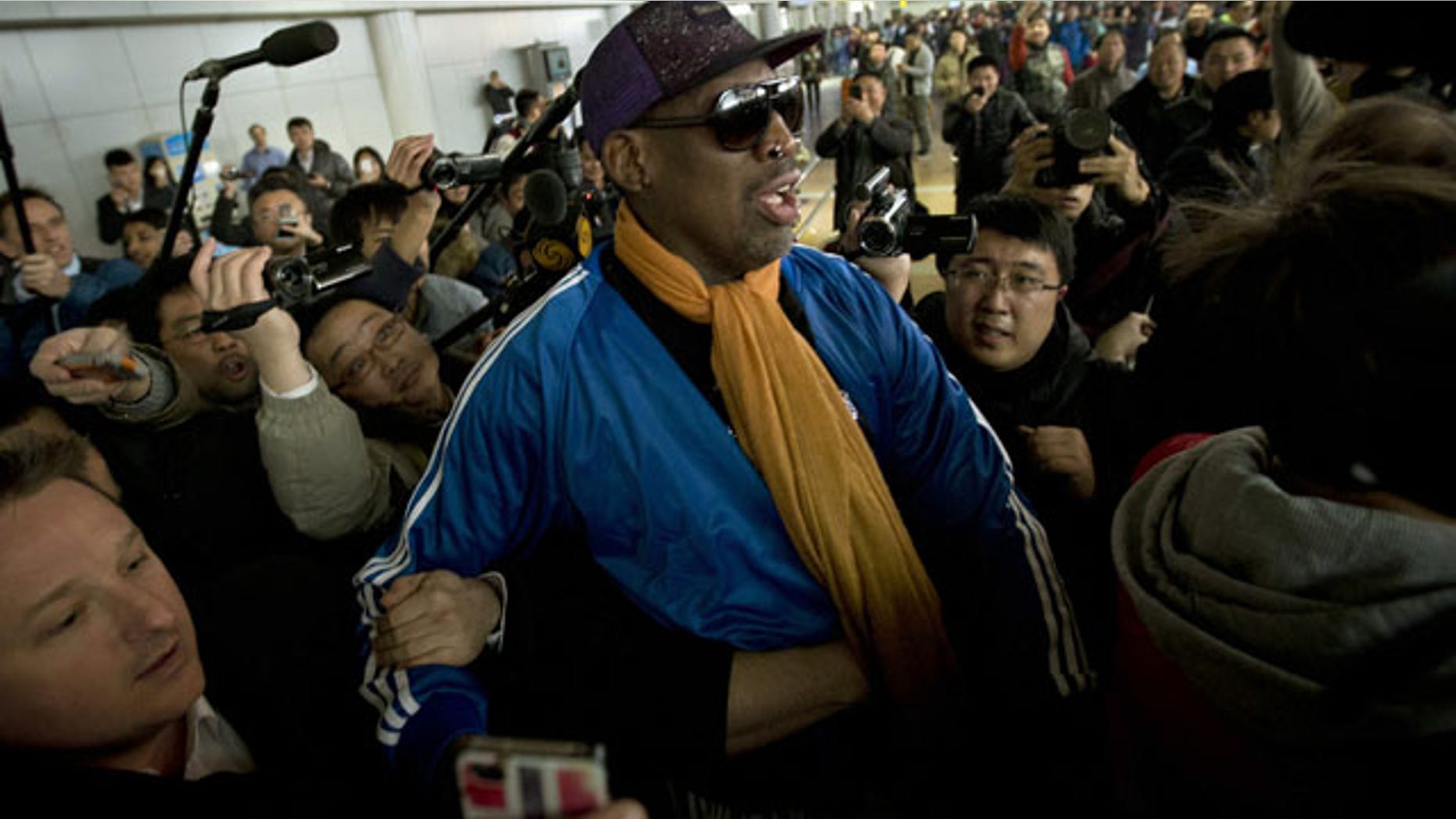January 13, 2014: Former NBA basketball player Dennis Rodman is followed by journalists as he arrives at the Capital International Airport in Beijing from Pyongyang. A squad of former basketball stars led by Rodman had a friendly game with North Korean basketball players in Pyongyang. (AP Photo/Alexander F. Yuan)