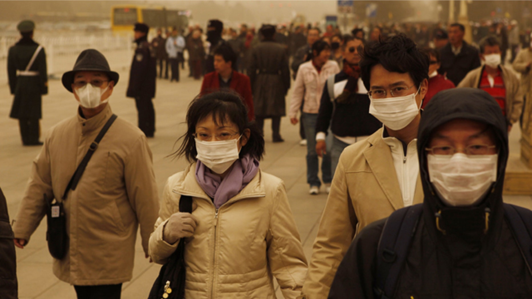 Tourists and residents wear masks as they visit Tiananmen gate during a sandstorm in Beijing, China, Monday, March 22, 2010.