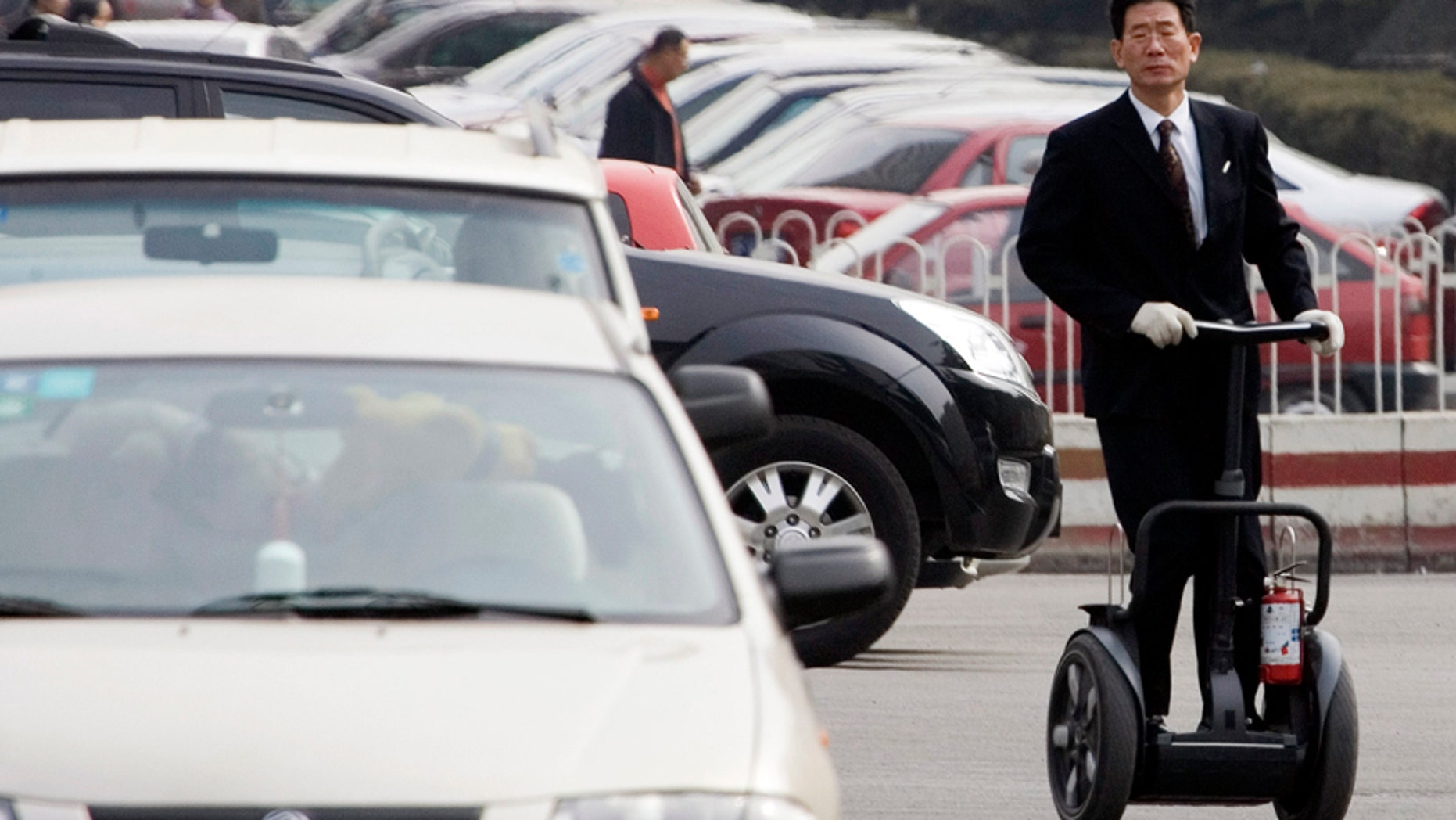 FILE - In this March 8, 2006 file photo, a Chinese man rolls on a Segway during his practice at a parking lot of a club where he sells the personal transporter in Beijing. Segway, the iconic but struggling U.S. maker of personal electric scooters, has been bought by a Chinese company. Beijing-based Ninebot Inc., which makes a range of short-distance motorized transport devices, said Wednesday, April 15, 2015 that it bought Segway for an undisclosed amount. Ninebot's purchase of New Hampshire-based Segway is the latest example of a Chinese company acquiring foreign brands or technology. (AP Photo/Ng Han Guan, File)