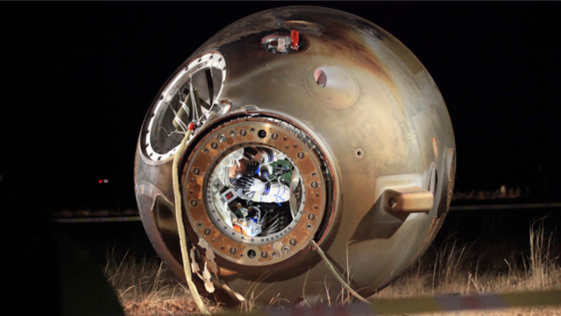 Nov. 17, 2011: A technician inspects the re-entry capsule of China's Shenzhou 8 spacecraft, which lies on its side with its hatch opened at a landing site in Siziwang Banner in north China's Inner Mongolia Autonomous Region. The unmanned Chinese spacecraft returned to Earth on Thursday night after it docked twice with an orbiting module in preparation for the country launching its own space station.