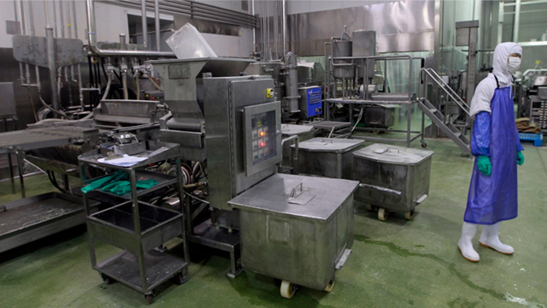 July 20, 2014: In this photo released by China's Xinhua News Agency, a worker stands near a shut-down machine at the workshop of Husi Food Co. in Shanghai, China, a meat supplier for McDonald's and KFC owned by OSI Group, a privately-held company based in Aurora, Ill. (AP Photo/Xinhua, Pei Xin)