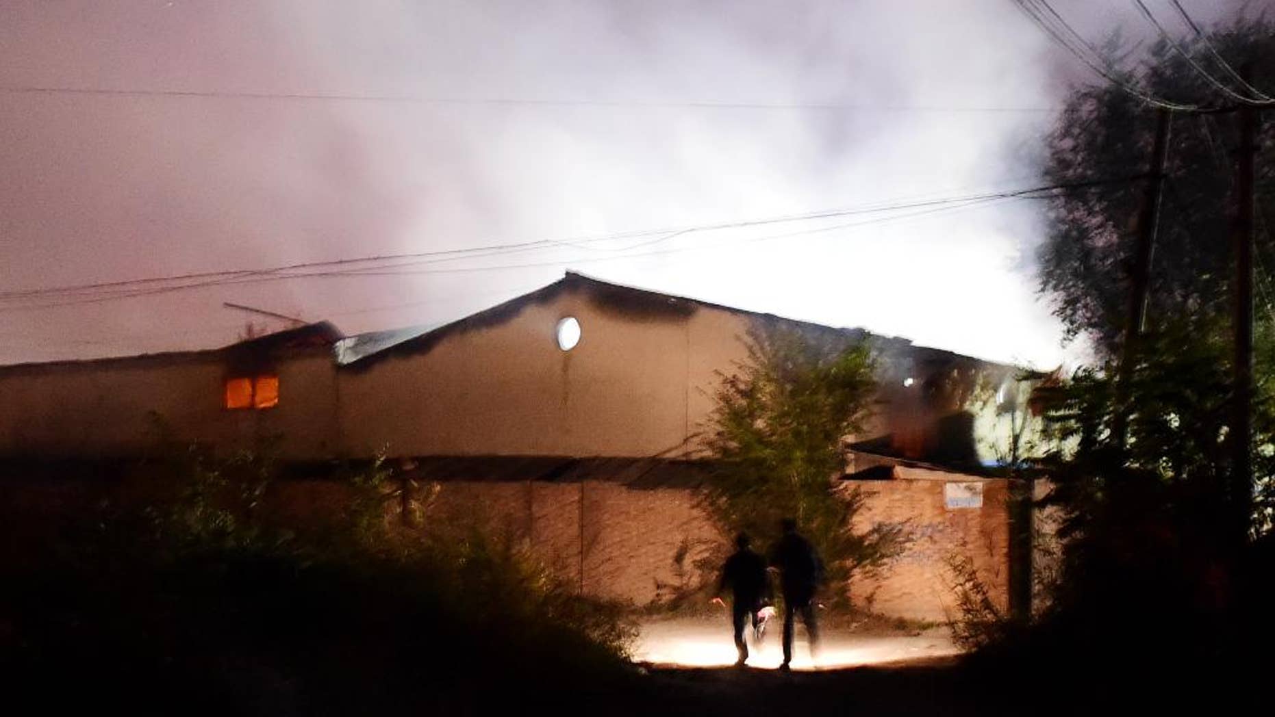In this photo released by China's Xinhua News Agency, people run near a blast site at Xiditou Village in the Beichen District of Tianjin, north China, Tuesday, Oct. 13, 2015. A blast hit a warehouse for alcohol materials in the city Monday night and started a fire. Two months after massive explosions left 173 people dead or missing, Tianijn has been rattled again by a warehouse blast. (Zhang Chenlin/Xinhua via AP) (Xinhua/Zhang Chenlin) (wf)