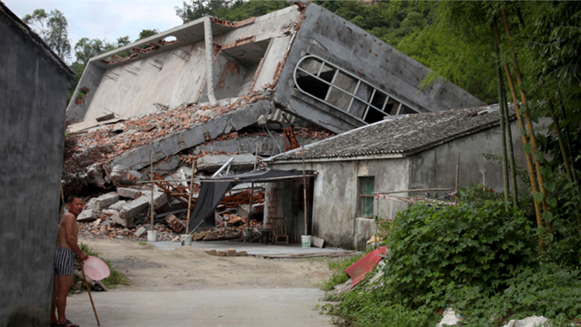 July 16, 2014: A man stands near the razed remains of a Catholic church in a village in Pingyang county of Wenzhou in eastern China's Zhejiang province. Across Zhejiang province, which hugs Chinas rocky southeastern coast, authorities have toppled, or threatened to topple, crosses at more than 130 churches. (AP Photo/Didi Tang)