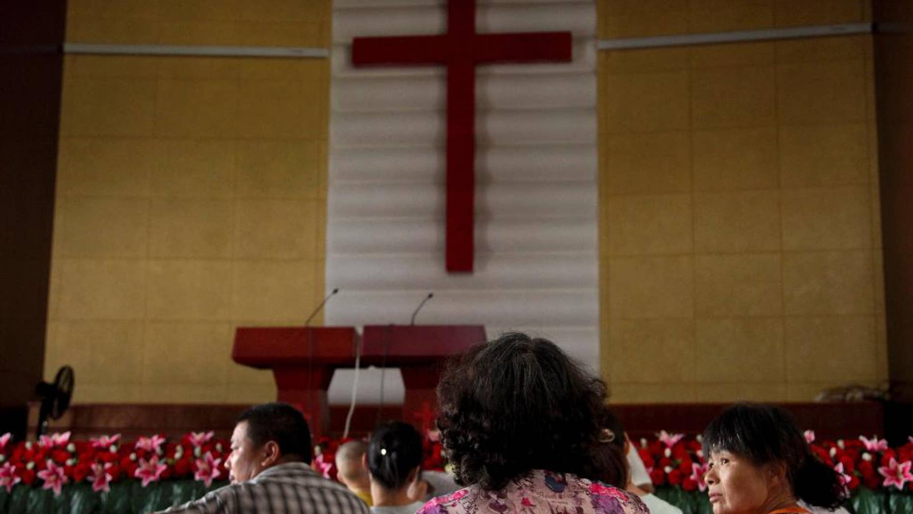 In this photo taken July 16, 2014, members of Yayu Christian Church gather in a hall during their turns to protect the rooftop cross from being demolished at the church in Yaxia village, Pingyang county in Wenzhou in eastern China's Zhejiang province. Across Zhejiang province, which hugs China’s rocky southeastern coast, authorities have toppled, or threatened to topple, crosses at more than 130 churches. (AP Photo/Didi Tang)