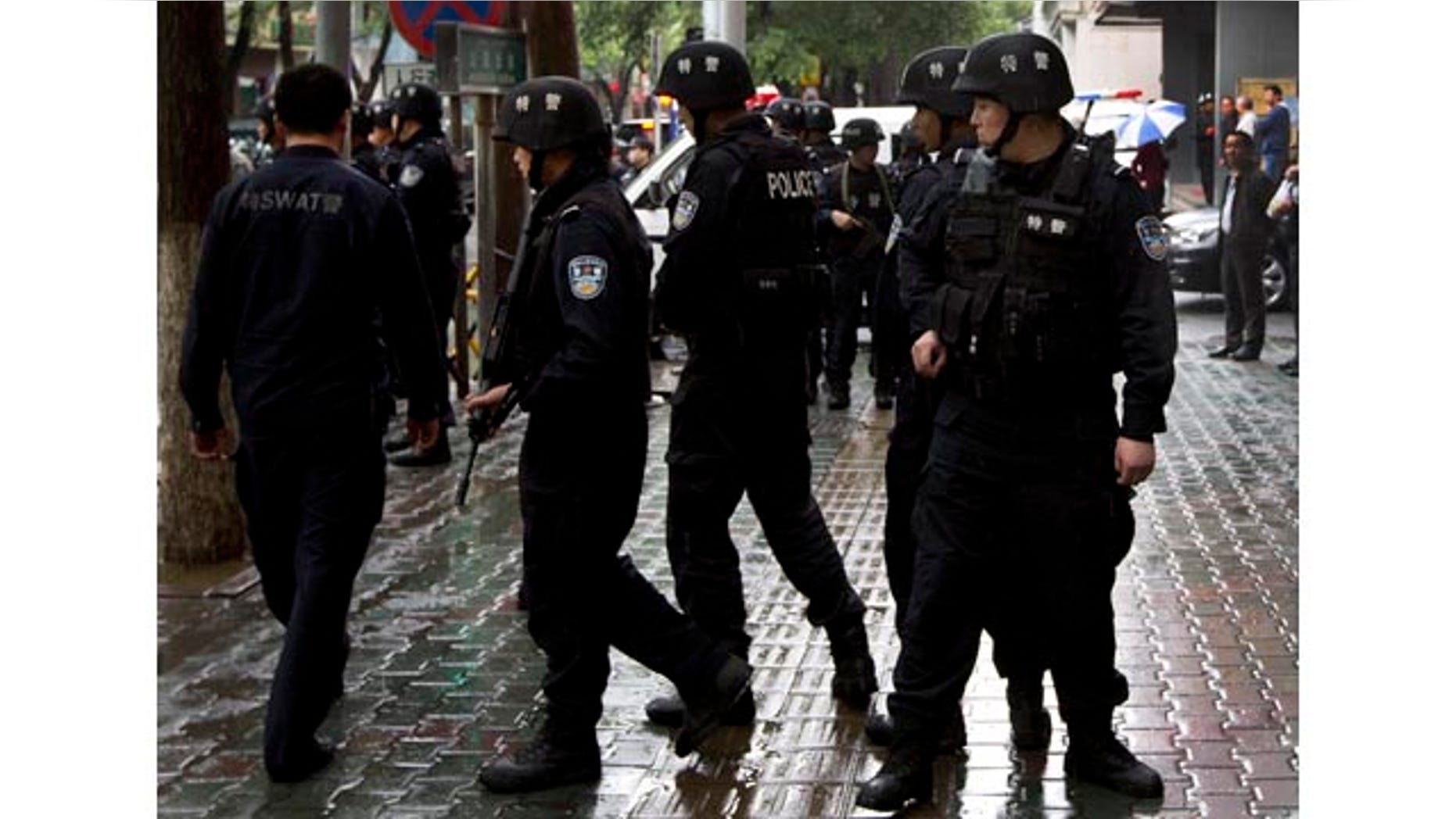 May 22, 2014: Armed policemen prepare to patrol near the site of an explosion in Urumqi, northwest China's Xinjiang Uygur Autonomous Region. (AP Photo/Andy Wong)