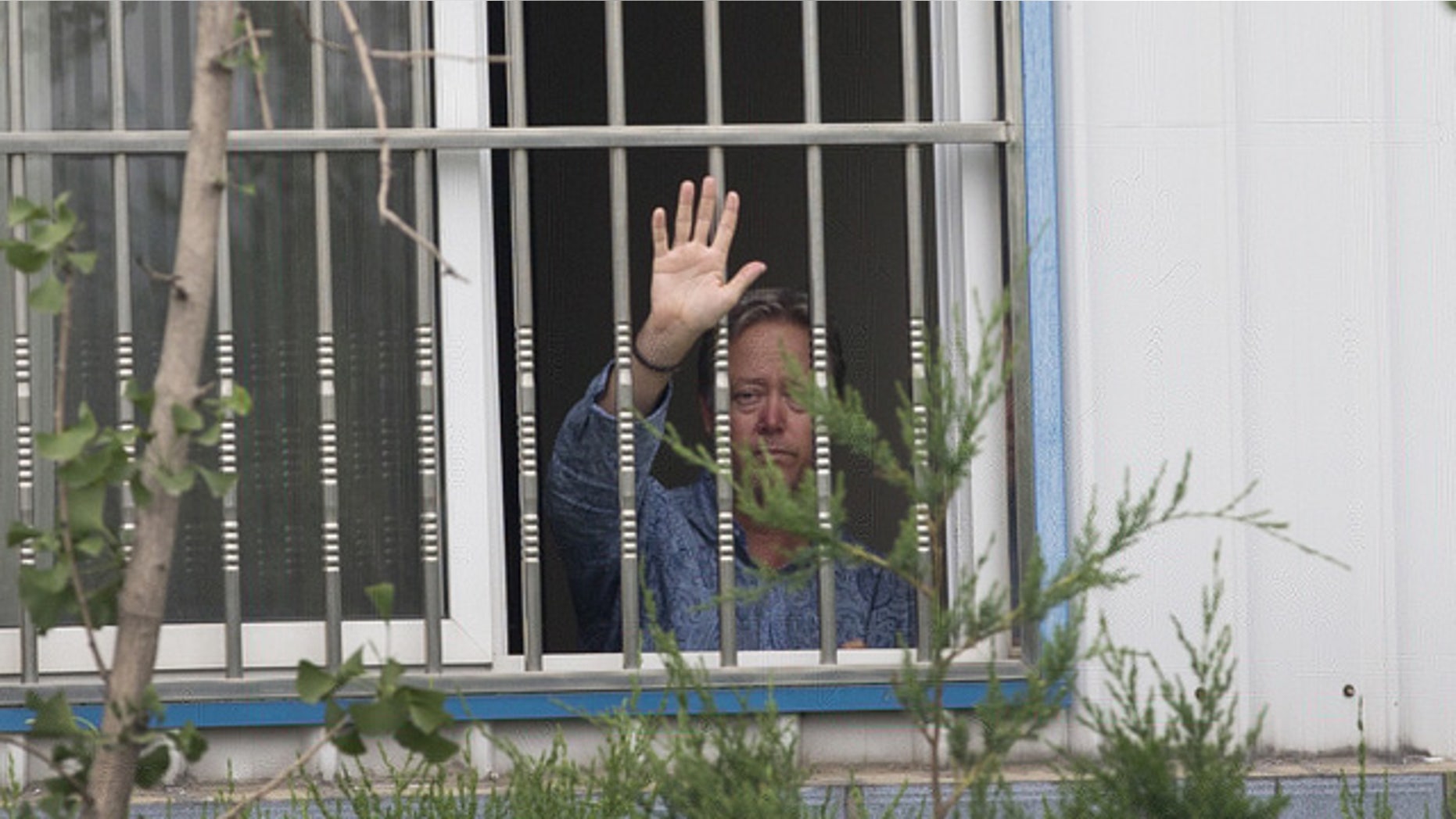 May 24, 2013: American Chip Starnes, co-owner of Specialty Medical Supplies waves from a window after he held hostage by workers inside the Specialty Medical Supplies plant at the Jinyurui Science and Technology Park in Qiao Zi township of Huairou District, on the outskirts of Beijing.