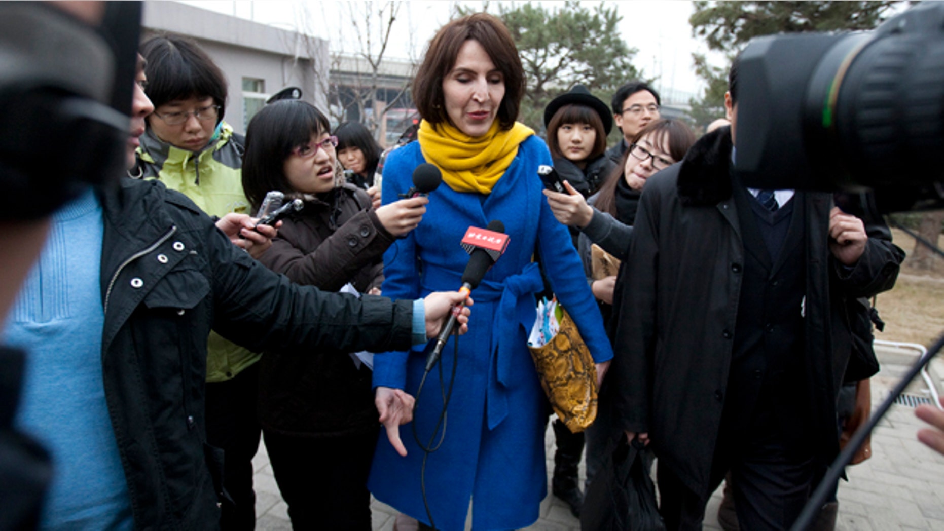 March 22, 2012: Kim Lee, center, wife of "Crazy English" founder Li Yang, is surrounded by local journalists as she walks into a court for her divorce trial in Beijing, China.