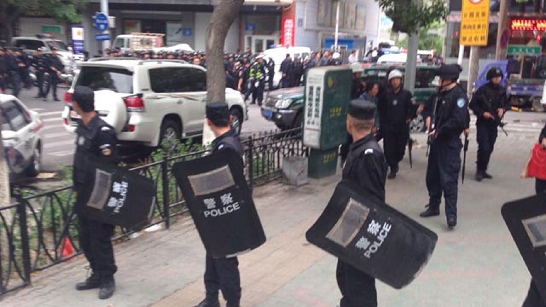 May 22, 2014: In this photo released by China's Xinhua News Agency, police officers stand guard near a blast site which has been cordoned off, in downtown Urumqi, capital of northwest China's Xinjiang Uygur Autonomous Region. (AP Photo/Cao Zhiheng)