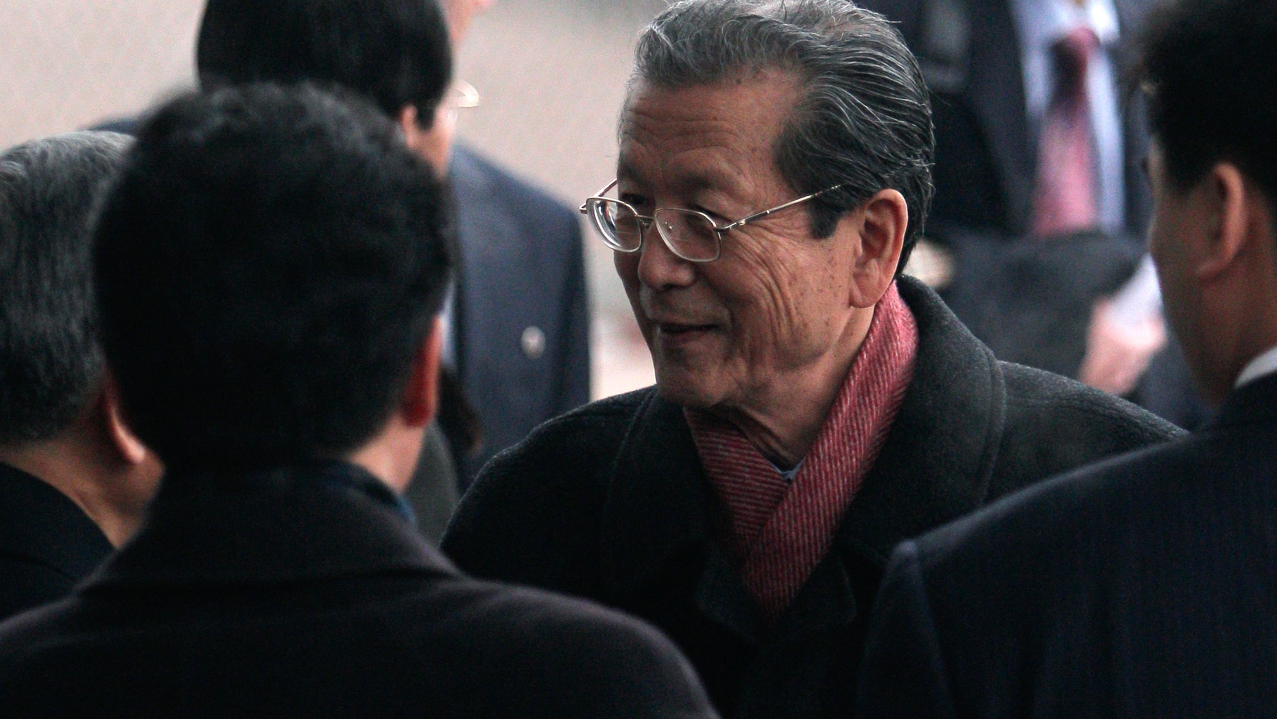 Choe Thae Bok, second from right, chairman of North Korea's Supreme People's Assembly, talks to an unidentified official after arriving at the airport in Beijing, China, Tuesday, Nov. 30, 2010.